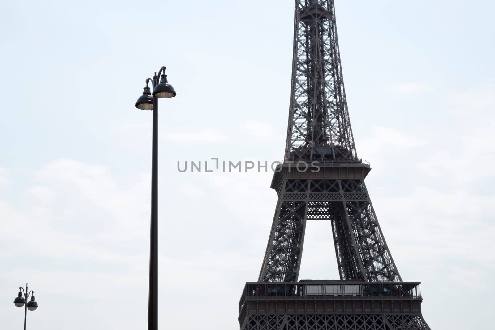 Eiffel Tower in Paris, France with street lamps beside it.