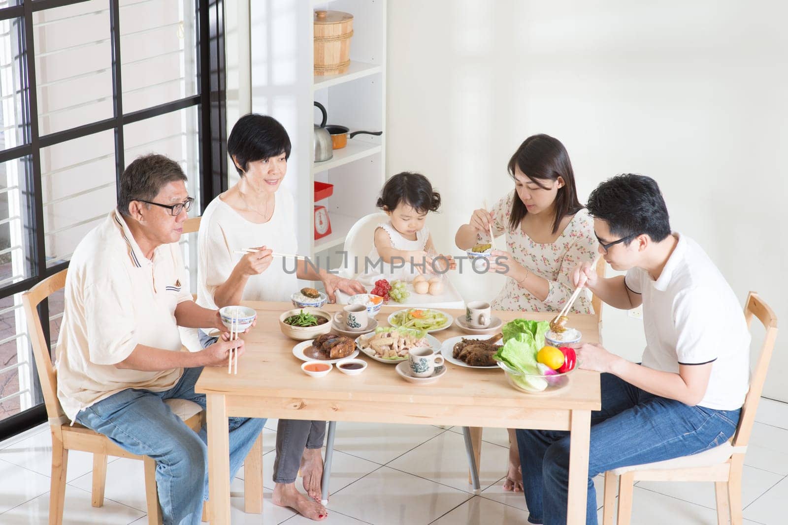 Happy Asian Chinese multi generations family dining at home.