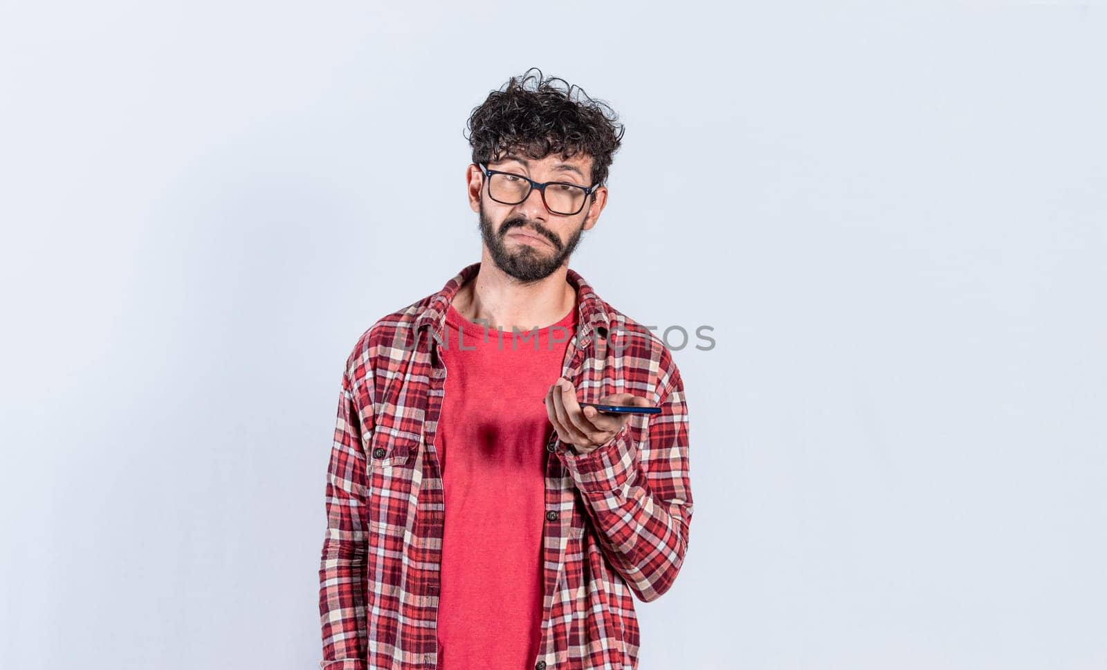 skeptical man with cell phone in hand, Person with indifferent face holding mobile on isolated background, Sad man with cell phone in hand