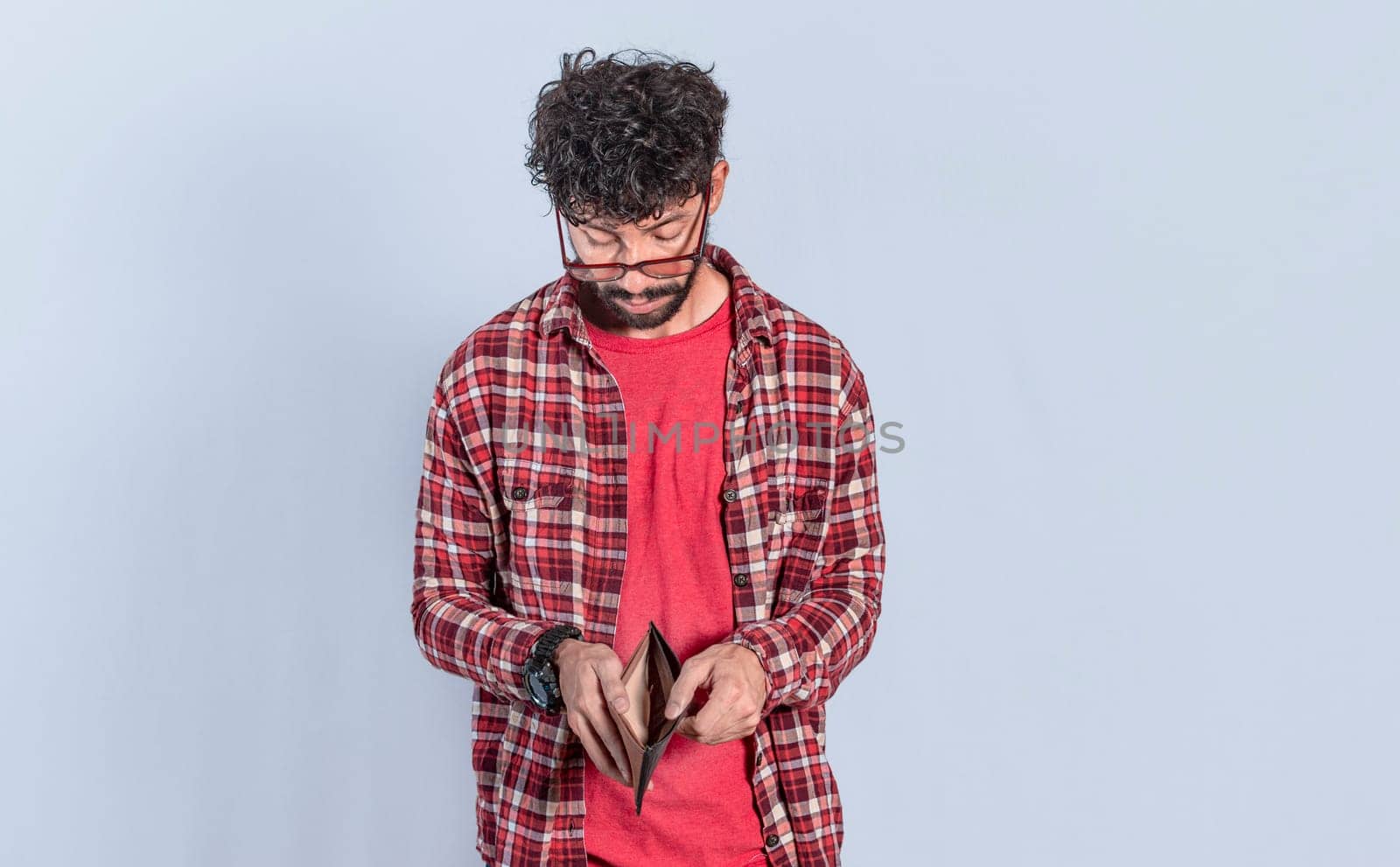 Unhappy man looking at his empty wallet, Person seeing his empty wallet with financial problems, Young man with wallet without money