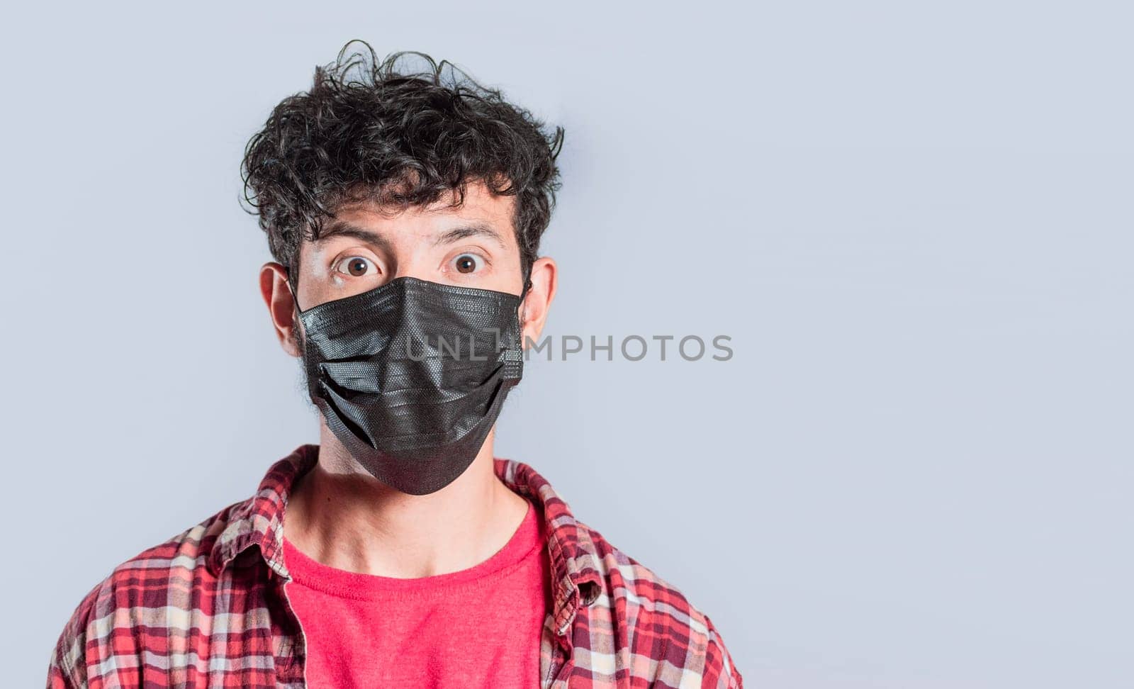 Close-up of handsome guy wearing protective mask, Close up of latin person wearing surgical mask isolated, Close-up of person wearing surgical mask on isolated background