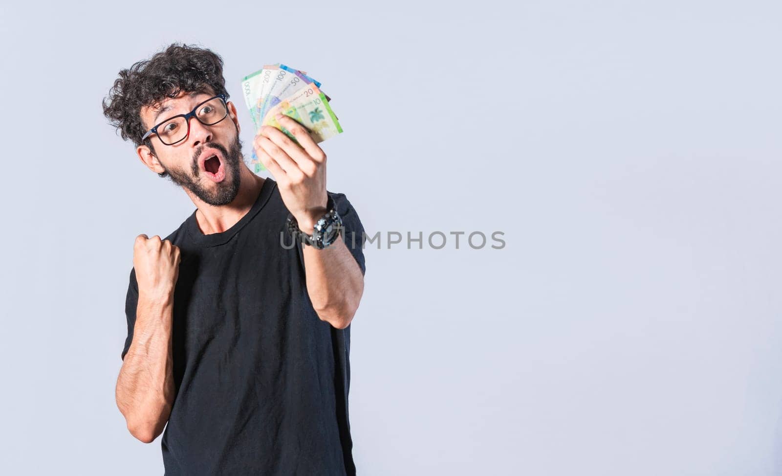 Excited man with money in his hand, astonished man with banknotes in his hand, concept of man earning money