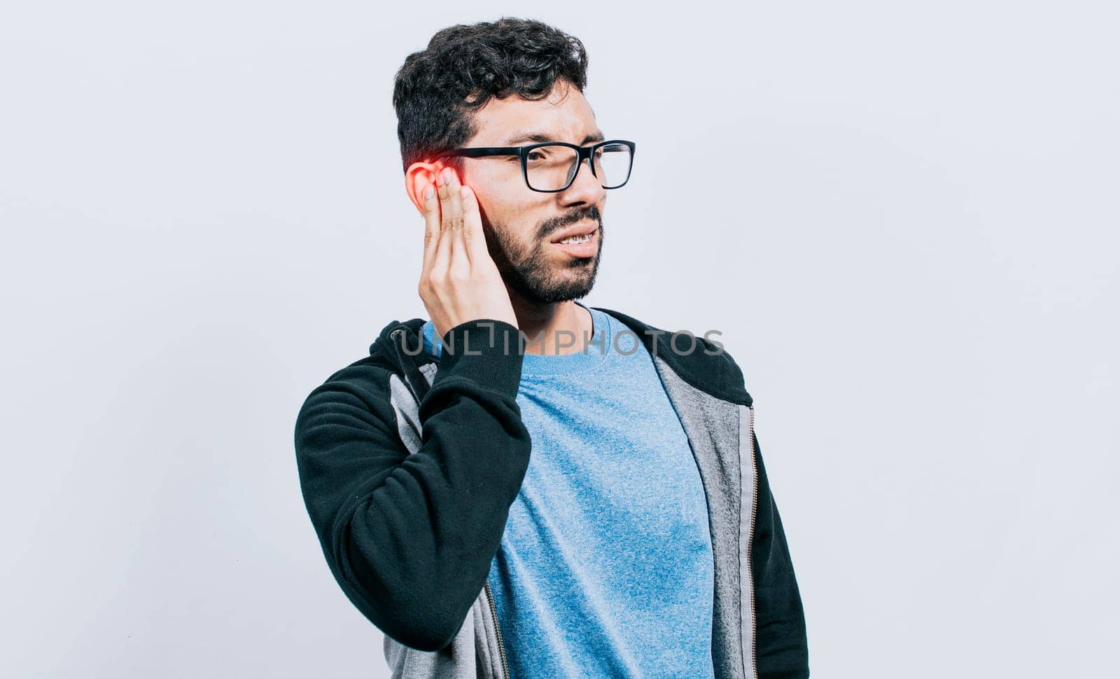 Person with ear pain, on isolated background, Suffering man massaging his ear isolated, concept of person with otitis and tinnitus