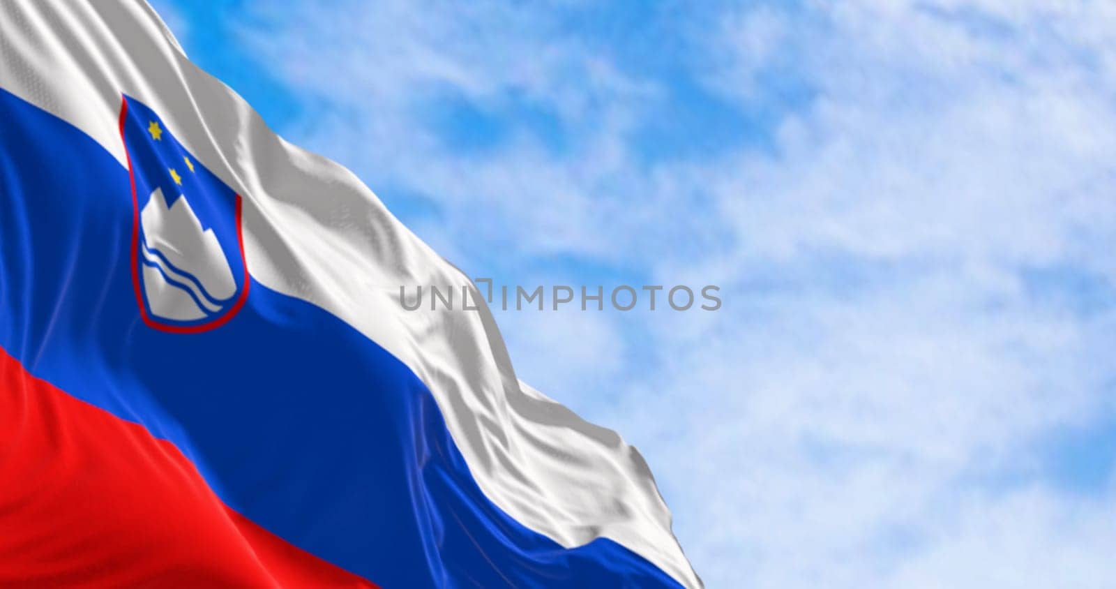 Slovenia national flag waving in the wind on a clear day. Three equal horizontal bands of white, blue, and red, with coat of arms in the upper hoist. 3d illustration render. Fluttering fabric.