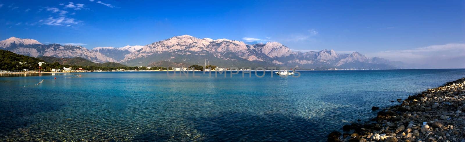 Kemer Antalia nice view of the sea. Beach Kemer Antalia with sand and mountains, the sea with the ship. Beautiful harbor near the sandy beach.