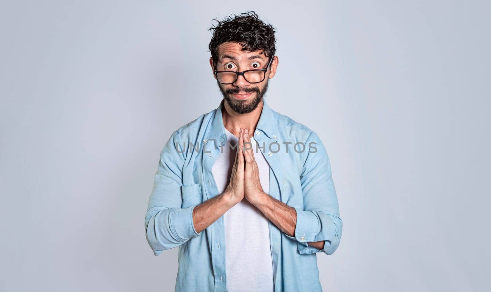 Pleading person asking for a favor, People with a pleading expression asking for a favor. Man putting his hands together asking for a favor