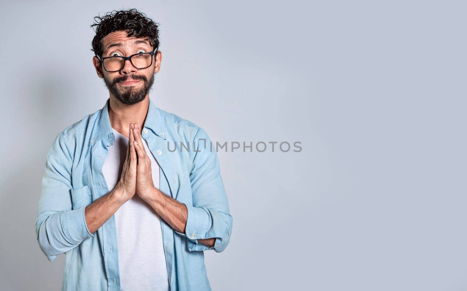 Man putting his hands together asking for a favor, Pleading person asking for a favor, People with a pleading expression asking for a favor.