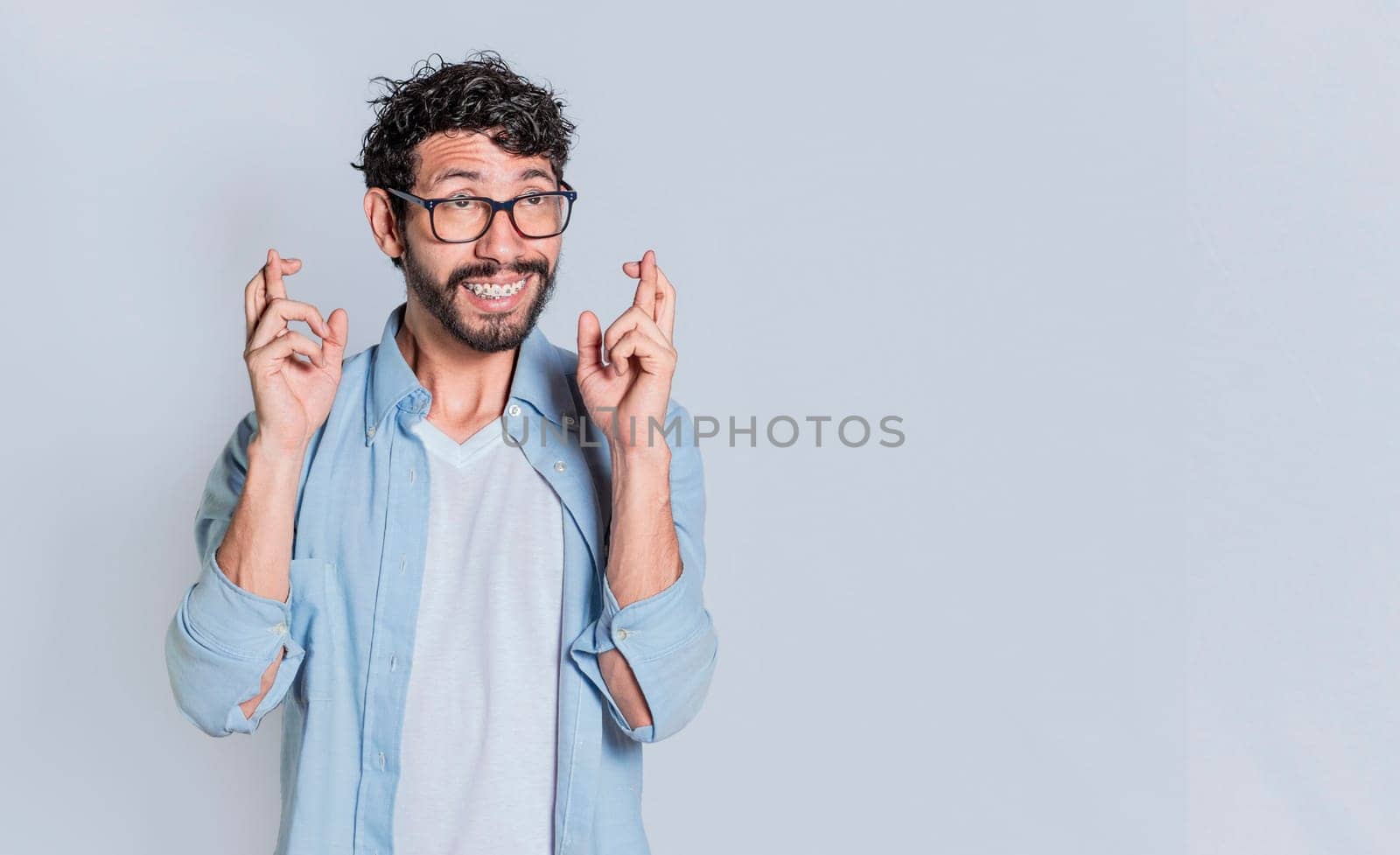 Positive people smiling making a wish while crossing his fingers. Happy man making a wish crossing his fingers, Concept of positive person making a wish and crossing his fingers on isolated background