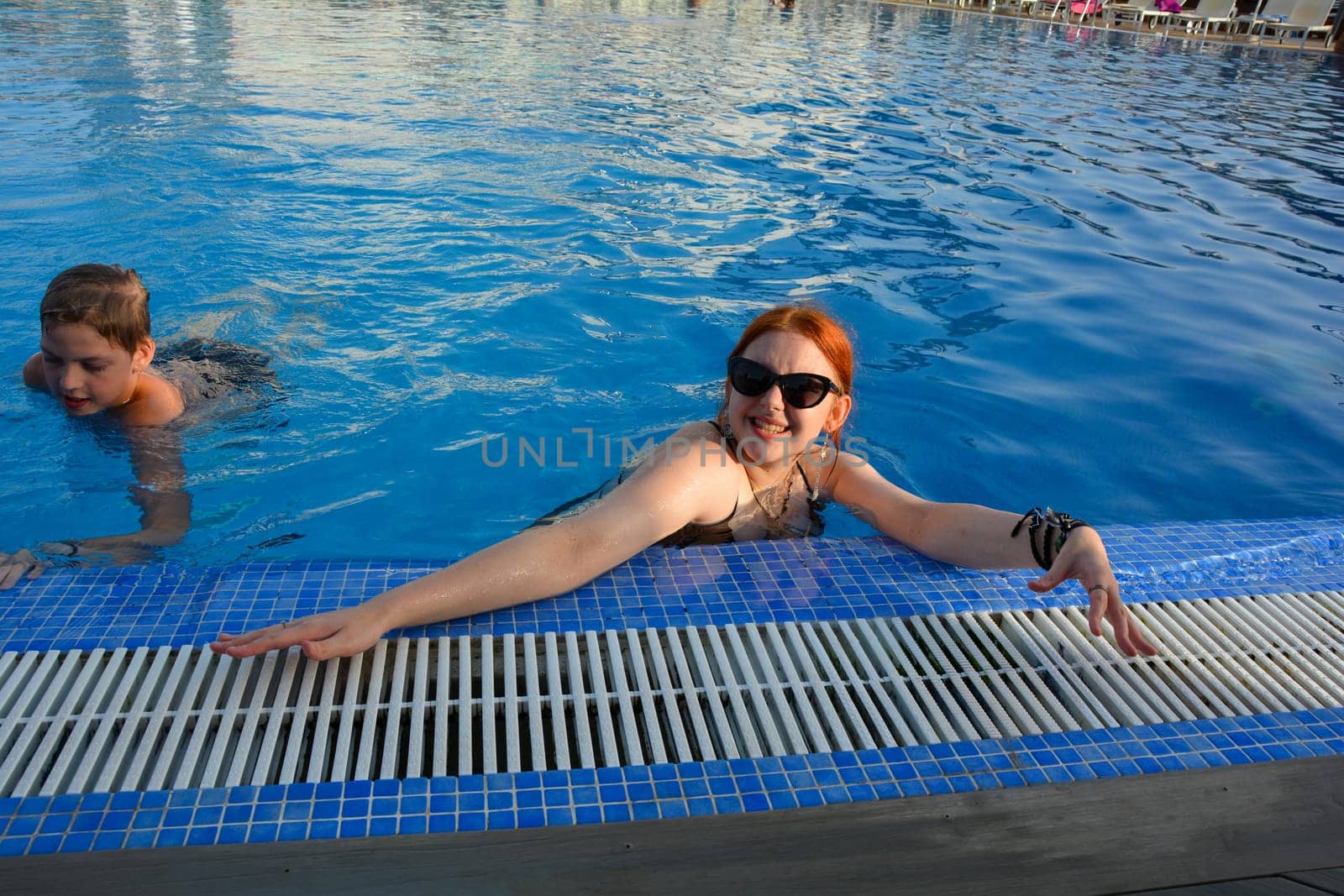 A boy and a teenage girl in a swimming pool