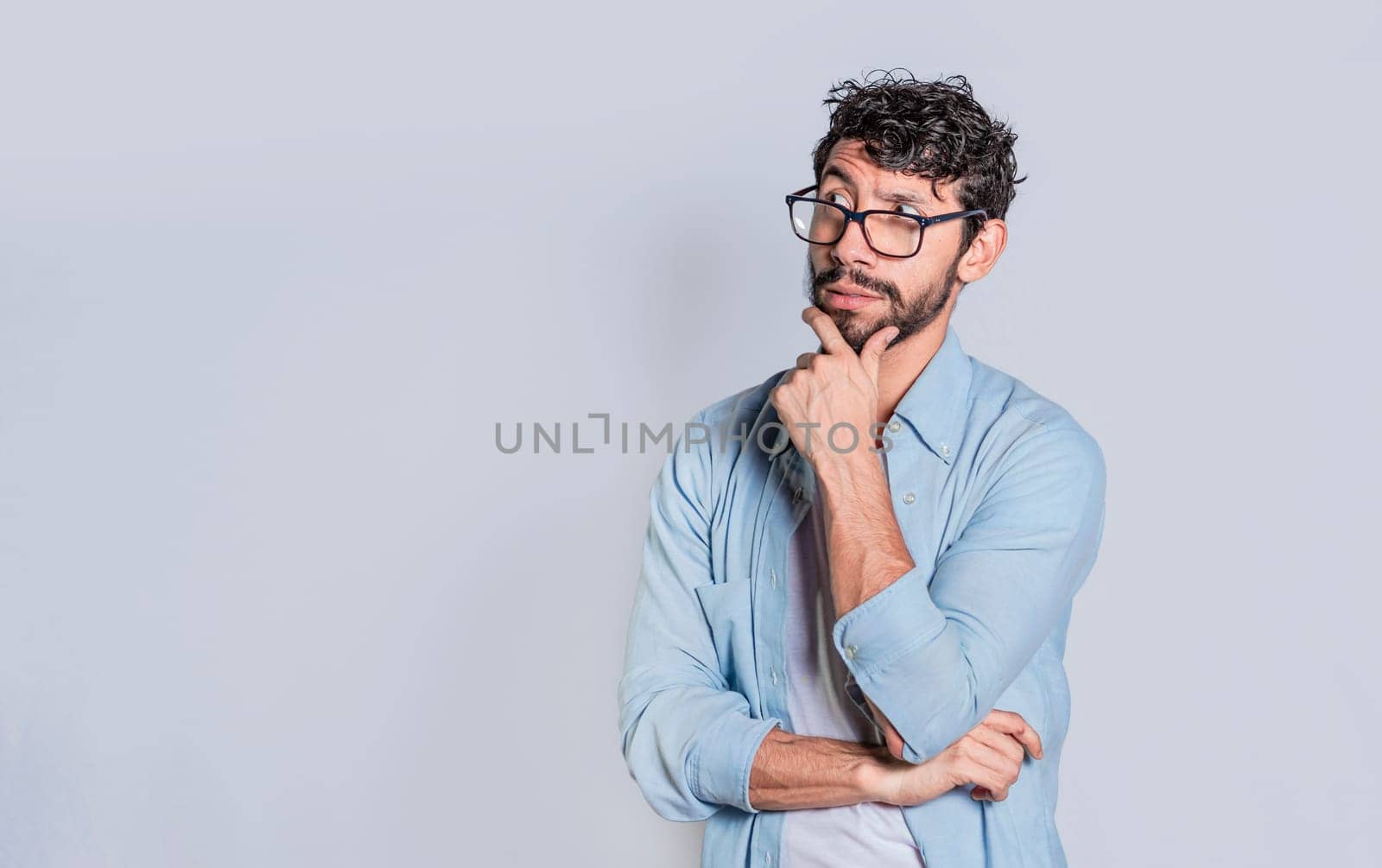 Man wondering with hand on chin on isolated background with copy space, Person wondering with hand on chin seeing blank space