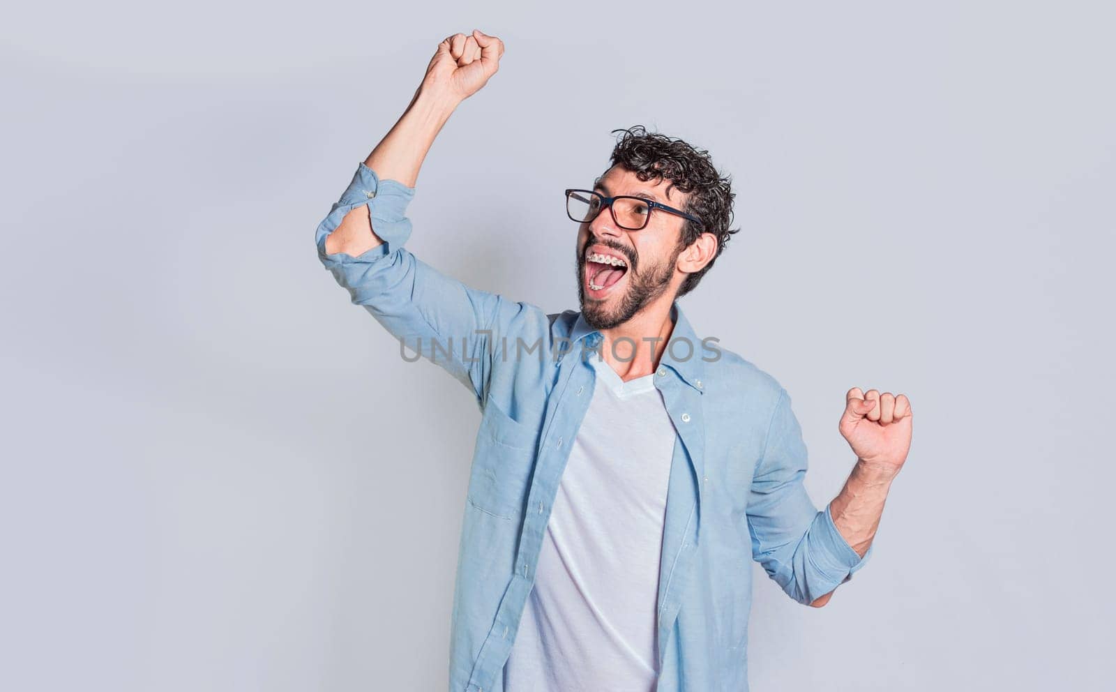 Handsome man raising his hand in victory isolated, Person celebrating and raising his hand in victory, Concept of person clenching and raising one hand in victory