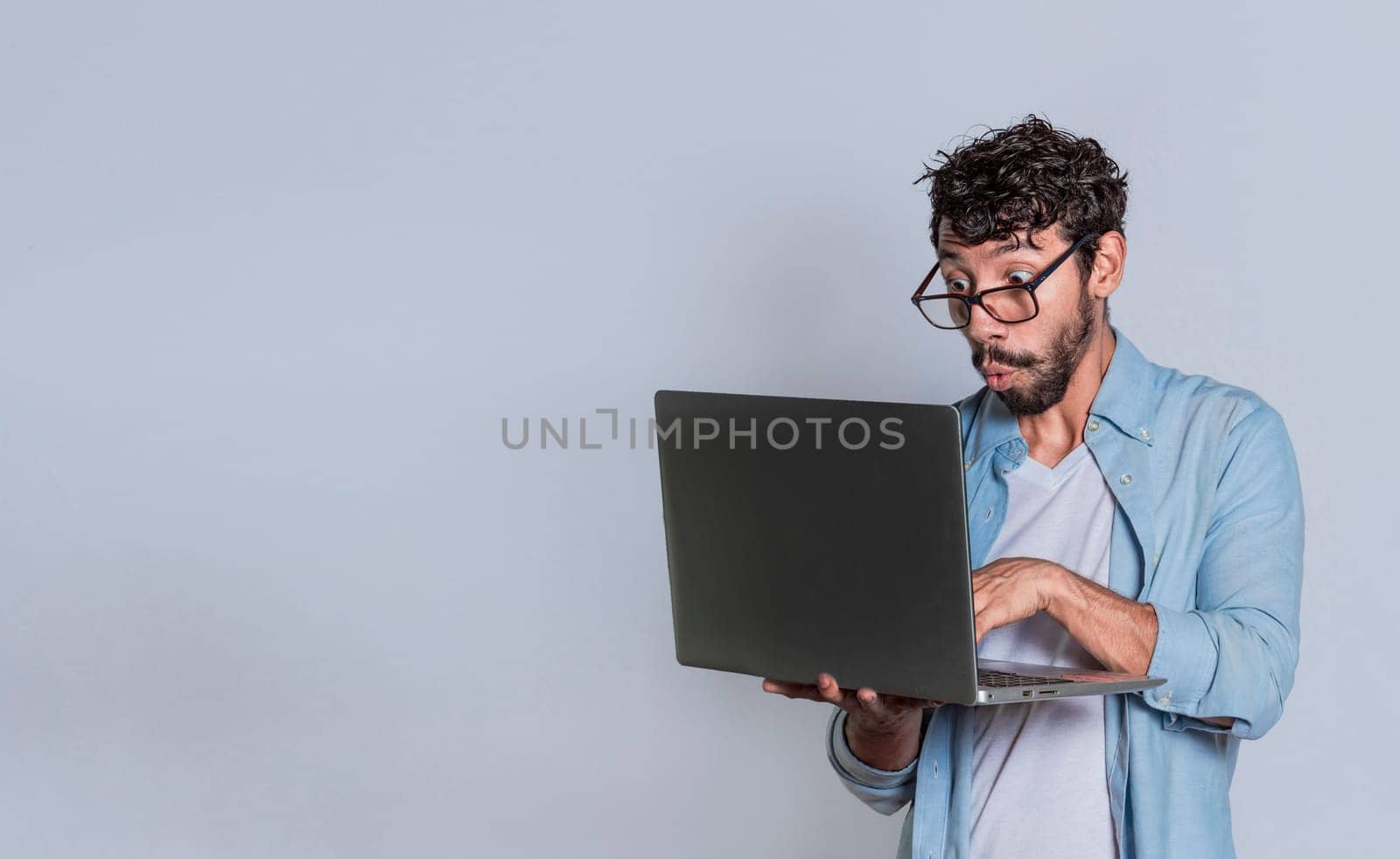 Surprised person looking at an offer on laptop, surprised people looking at a promotion on laptop isolated. Amazed handsome man with laptop isolated.