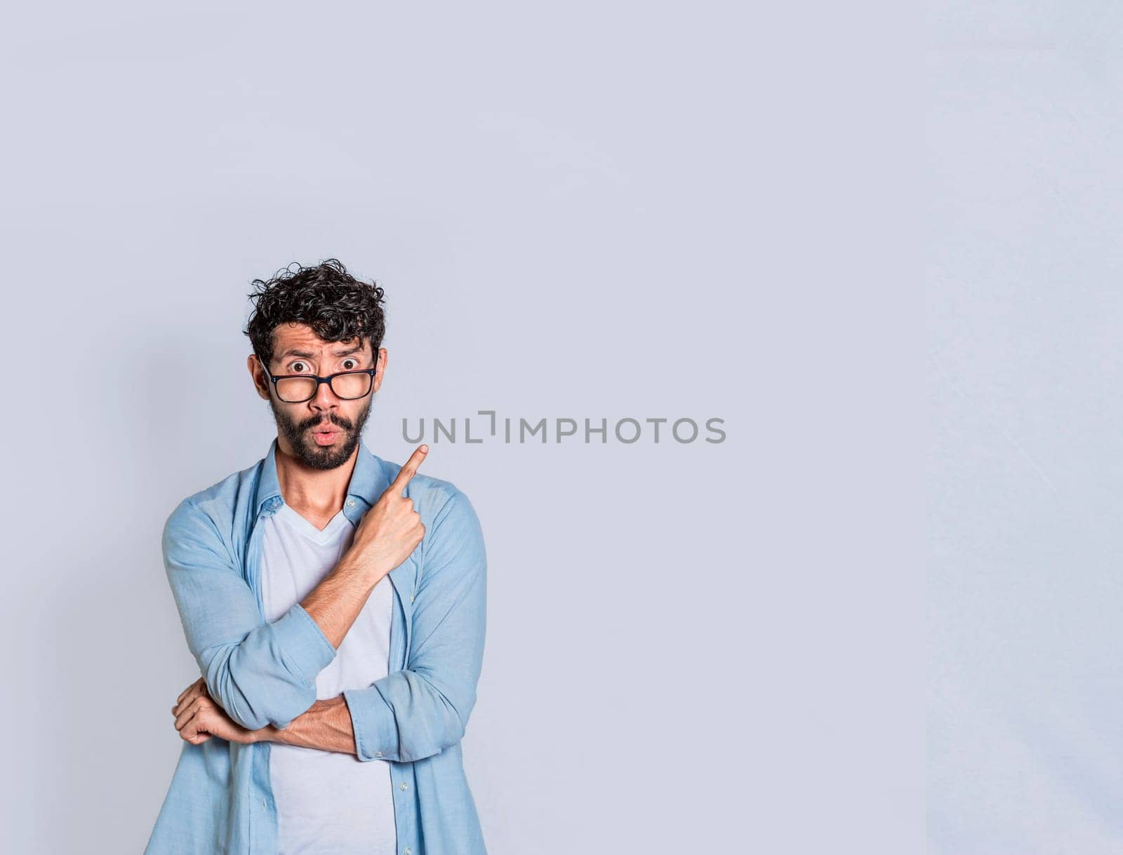 Surprised person pointing an advertisement to the right , Amazed handsome man pointing his finger to the right, Concept of a person pointing an advertisement.