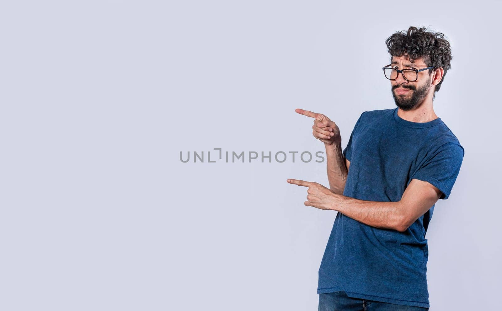 Smiling handsome man pointing two fingers to the side, Friendly handsome man pointing two fingers to the side, Concept of a young man pointing at a banner