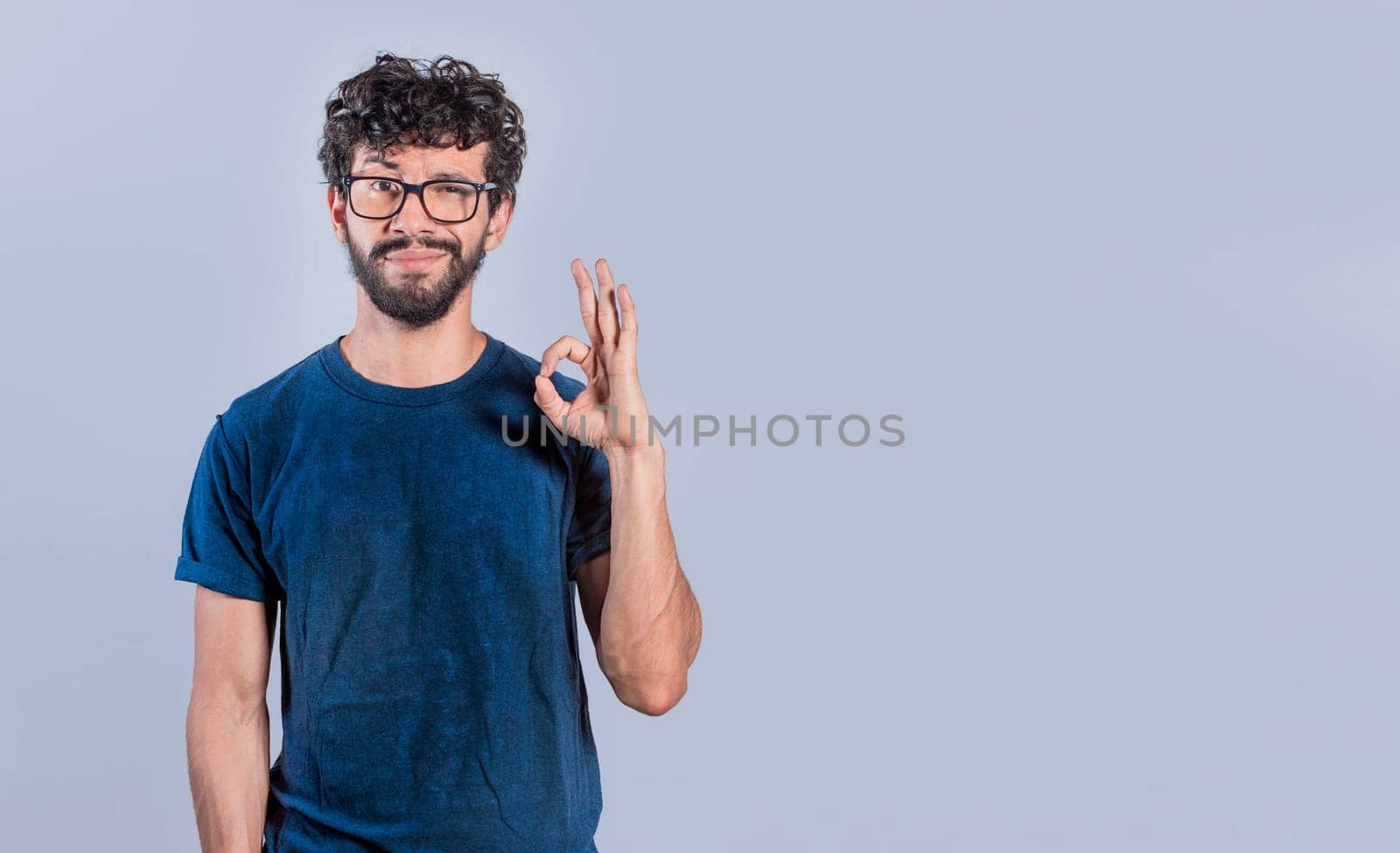 Handsome man gesturing everything is ok, Person making ok gesture, Smiling man showing ok gesture looking at camera, expression of everything is fine.