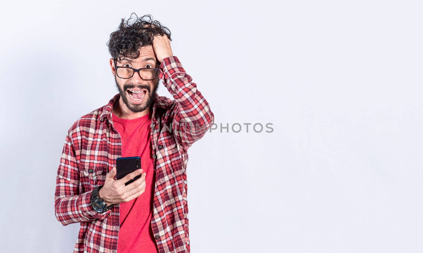 Worried man clutching his head holding cellphone, Worried person with cellphone holding his head on isolated background, Bad news concept on cellphone