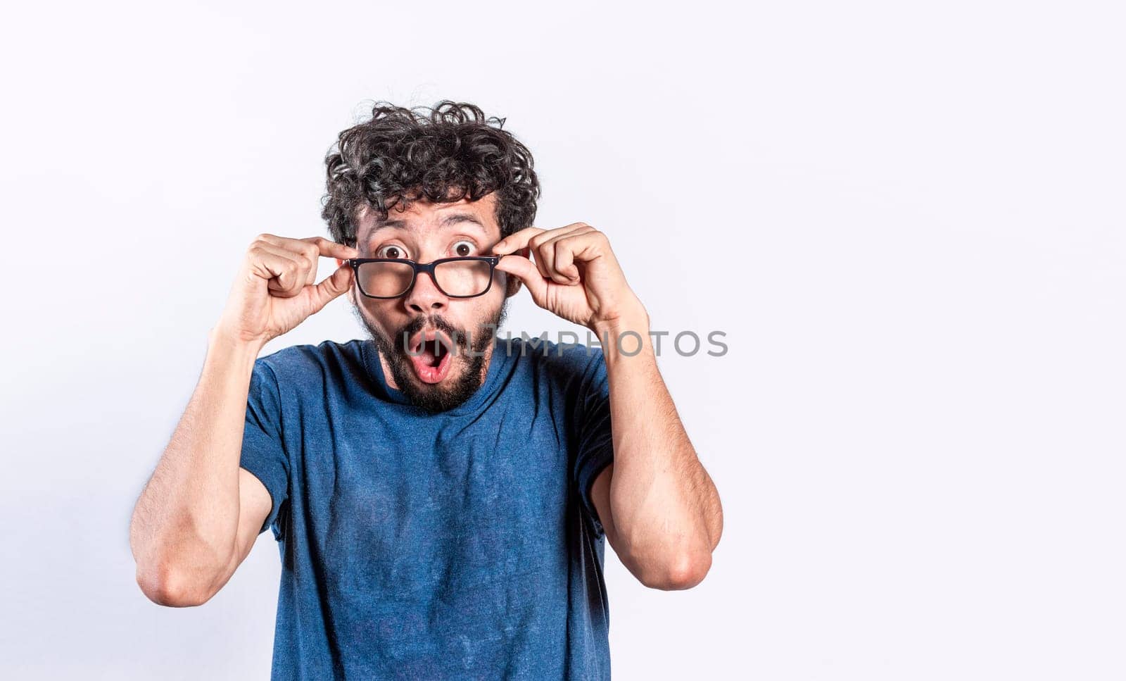 Surprised handsome man taking off his glasses, Person taking off his glasses surprised by a promotion, man opening his mouth surprised taking off his glasses