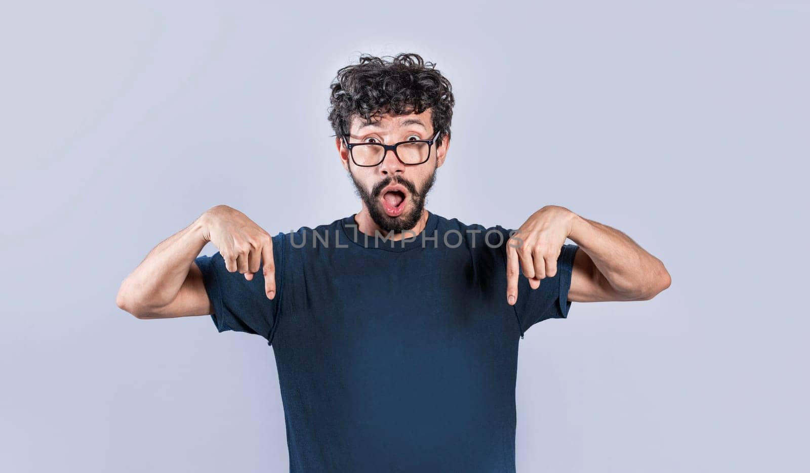 Amazed man pointing down isolated, Shocked person pointing down with fingers isolated, Amazed young man pointing down