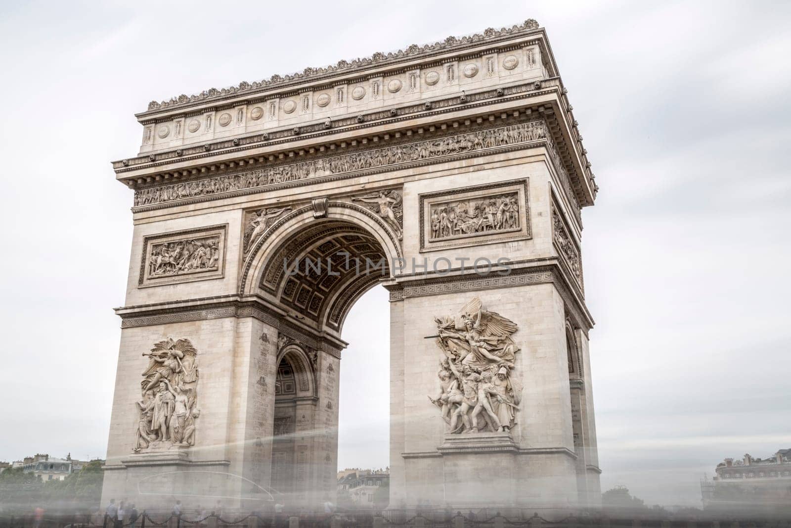 Arch of Triumph in Paris, France with cloudy sky.