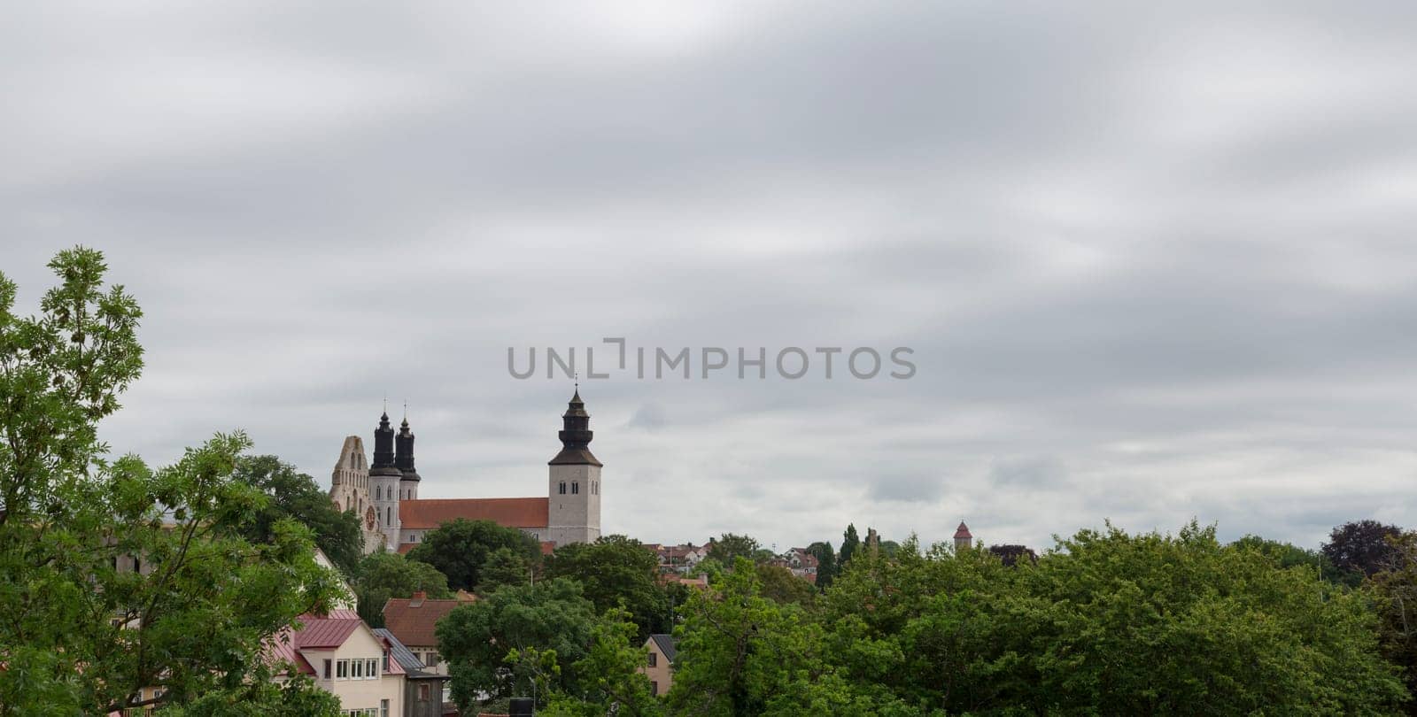 The Visby Church on Gotland in Sweden with a cloudy sky and trees.