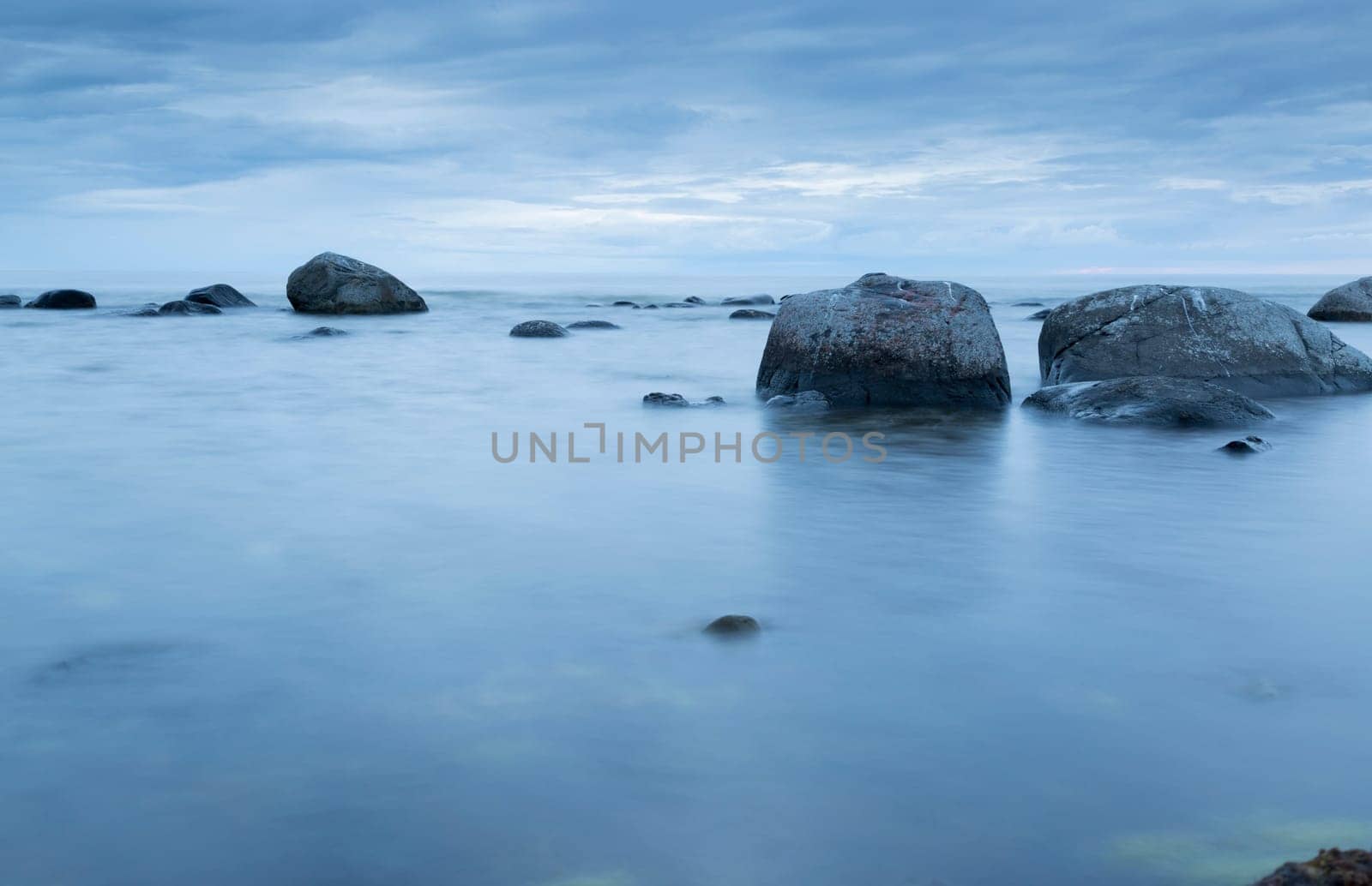 Calm Ocean with Rocks and blue ocean and sky.