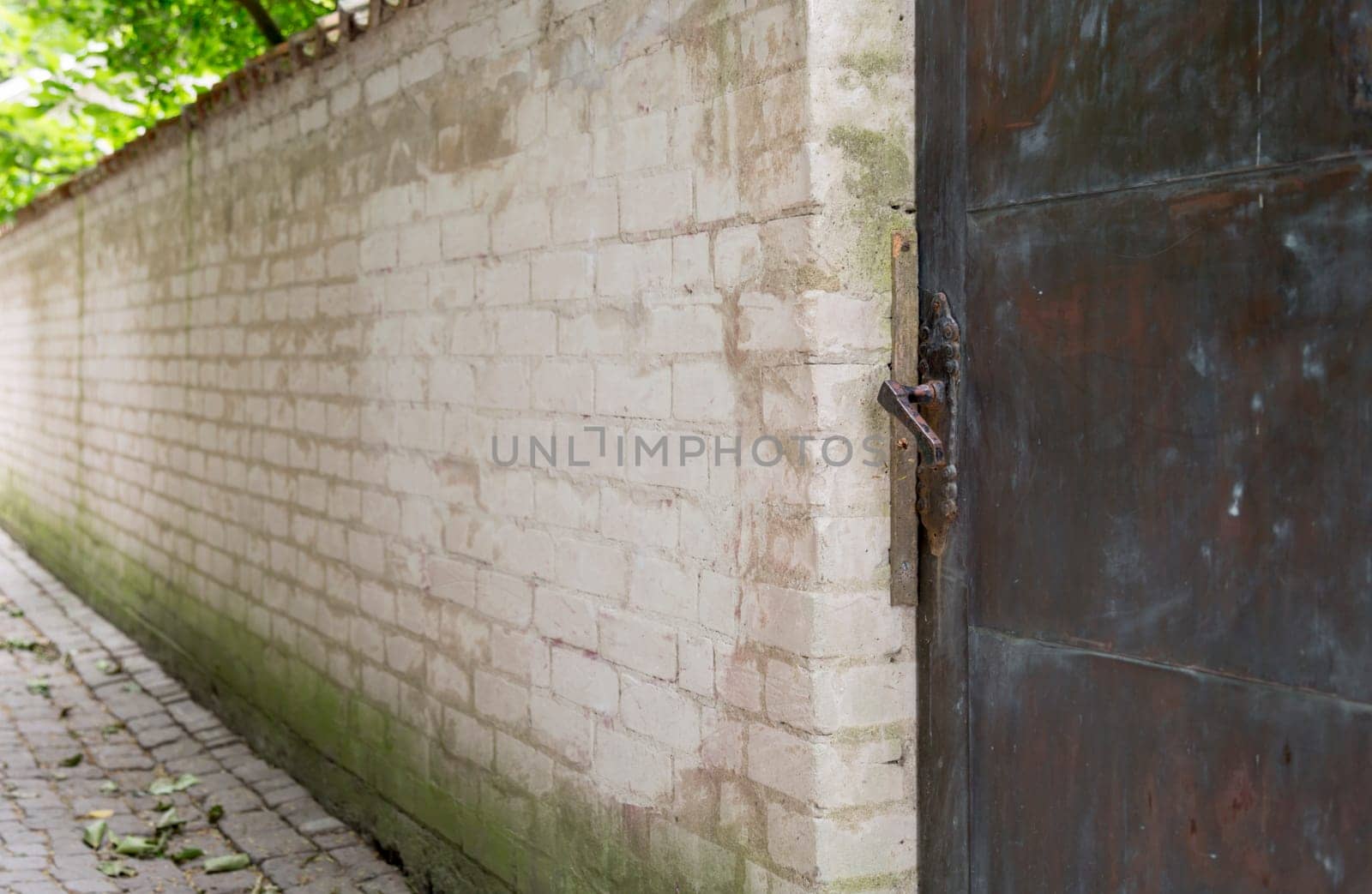 Metal Door in Brick Wall with cobblestone street.