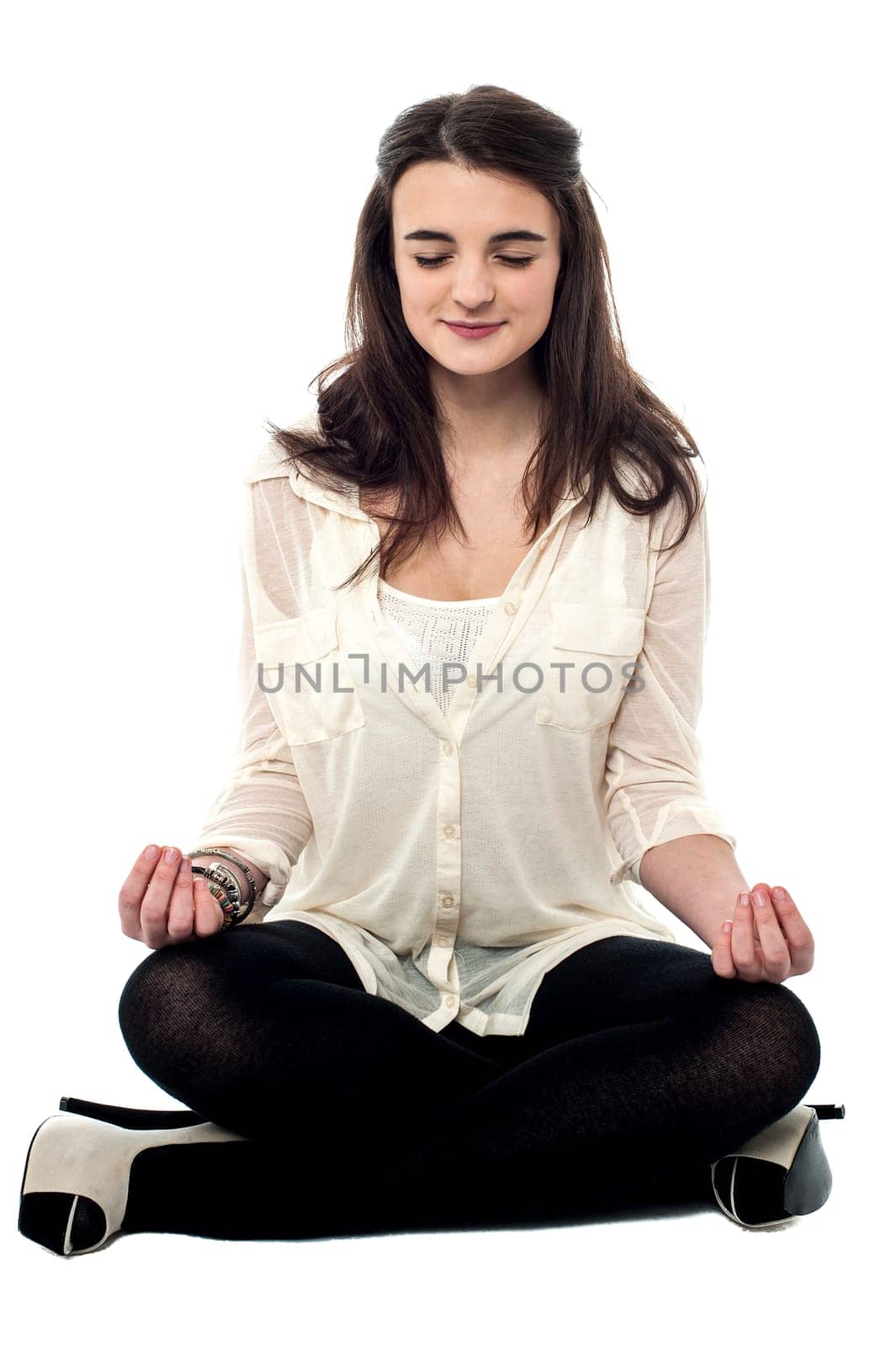 Teen girl practicing yoga in lotus position