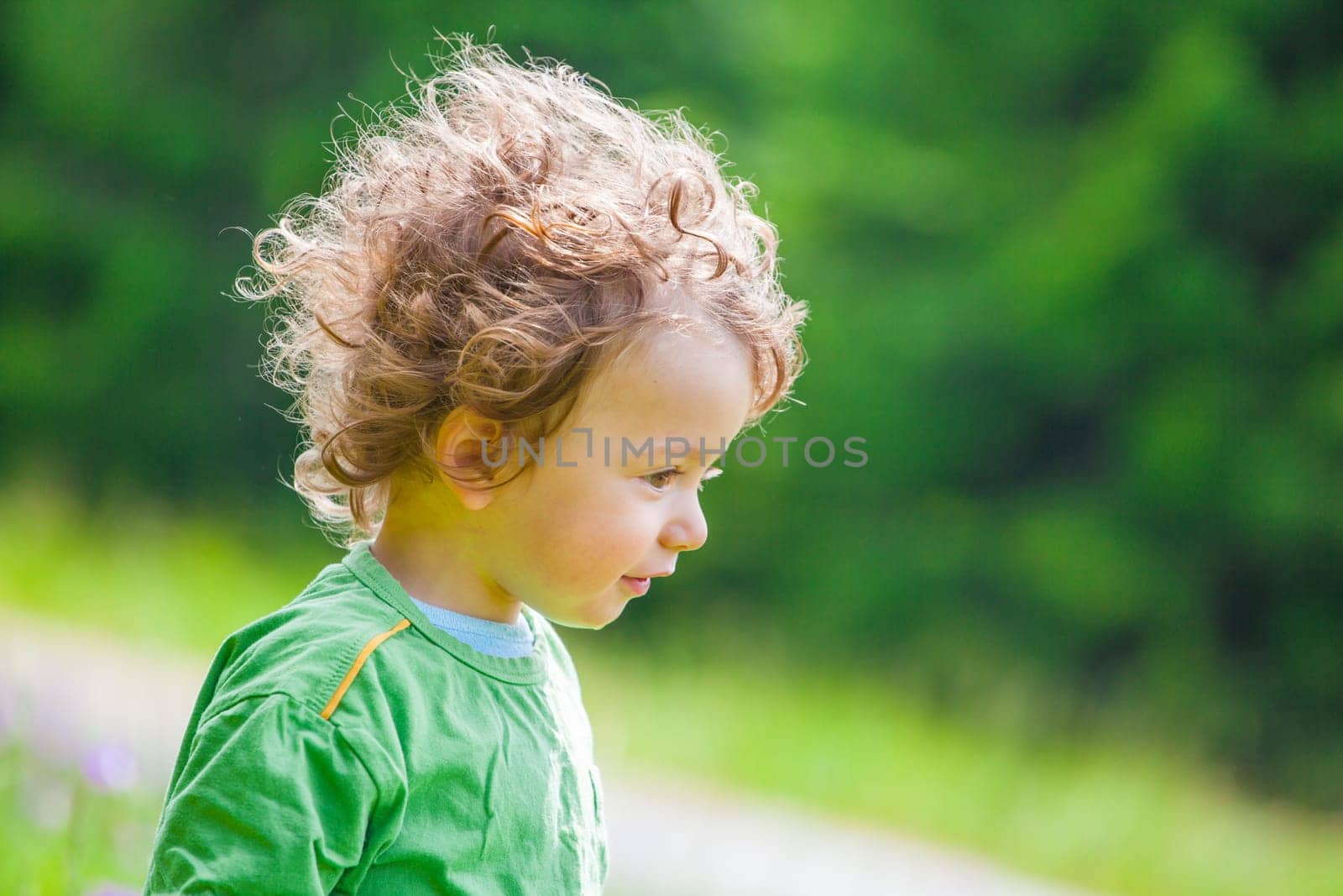 Portrait of 1 year old baby boy having fun on a mountain meadow.