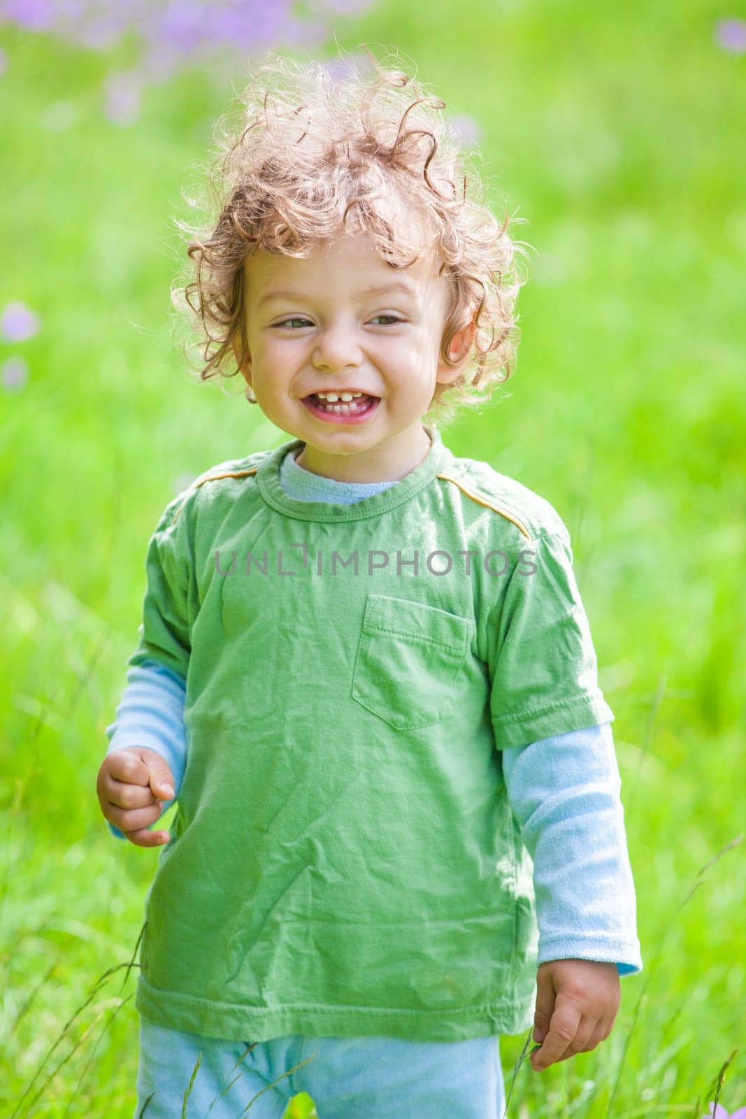 Portrait of 1 year old baby boy having fun on a mountain meadow.