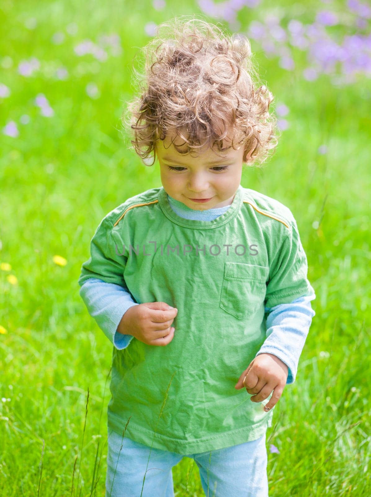Portrait of 1 year old baby boy having fun on a mountain meadow.