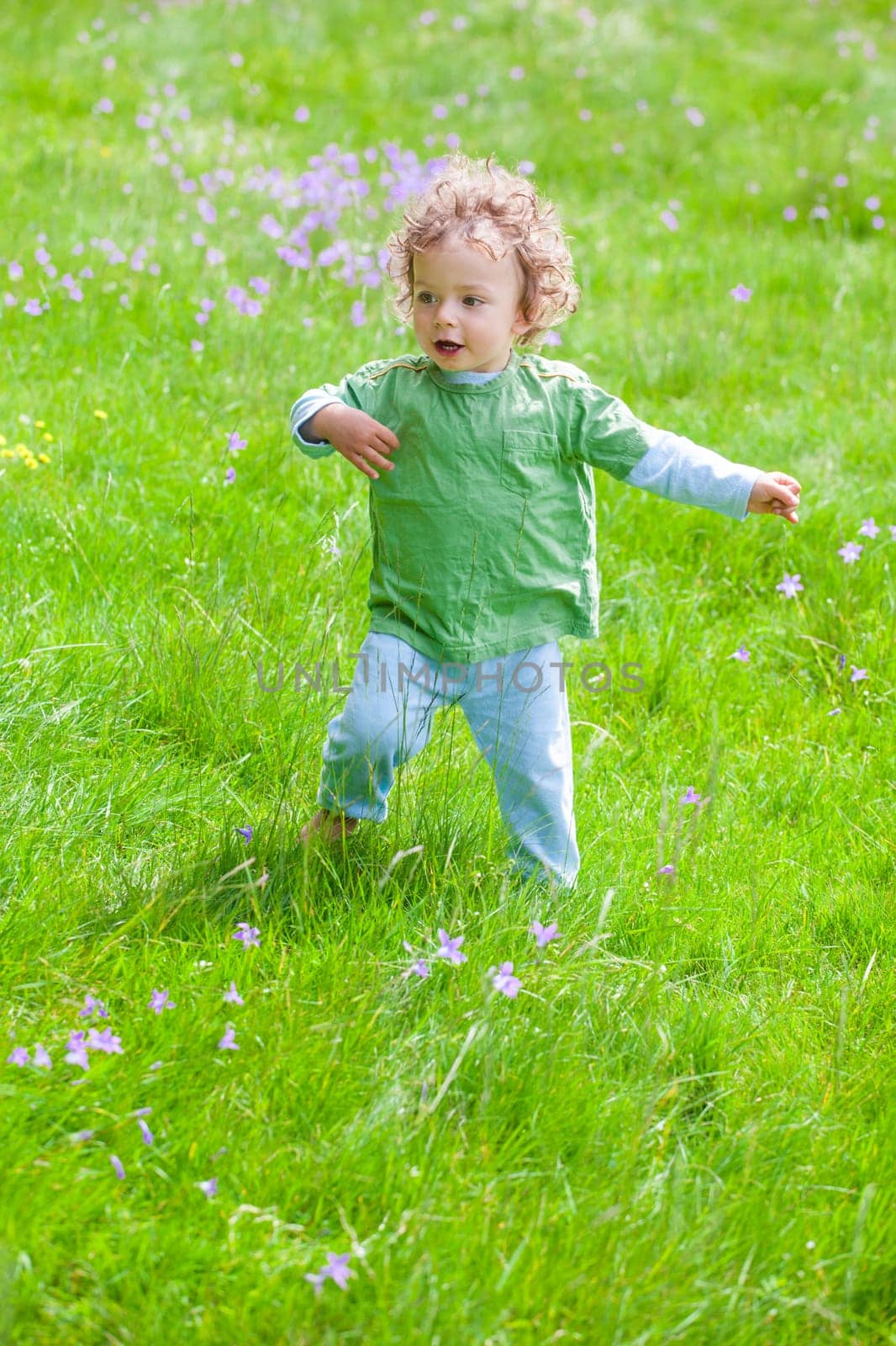Portrait of 1 year old baby boy having fun on a mountain meadow.