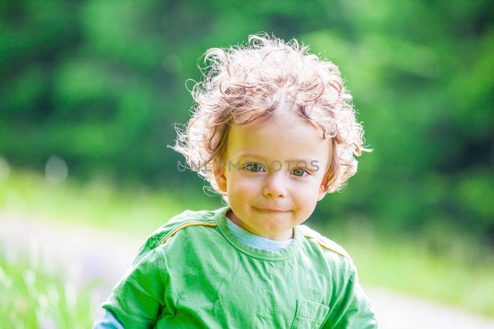Portrait of 1 year old baby boy having fun on a mountain meadow.
