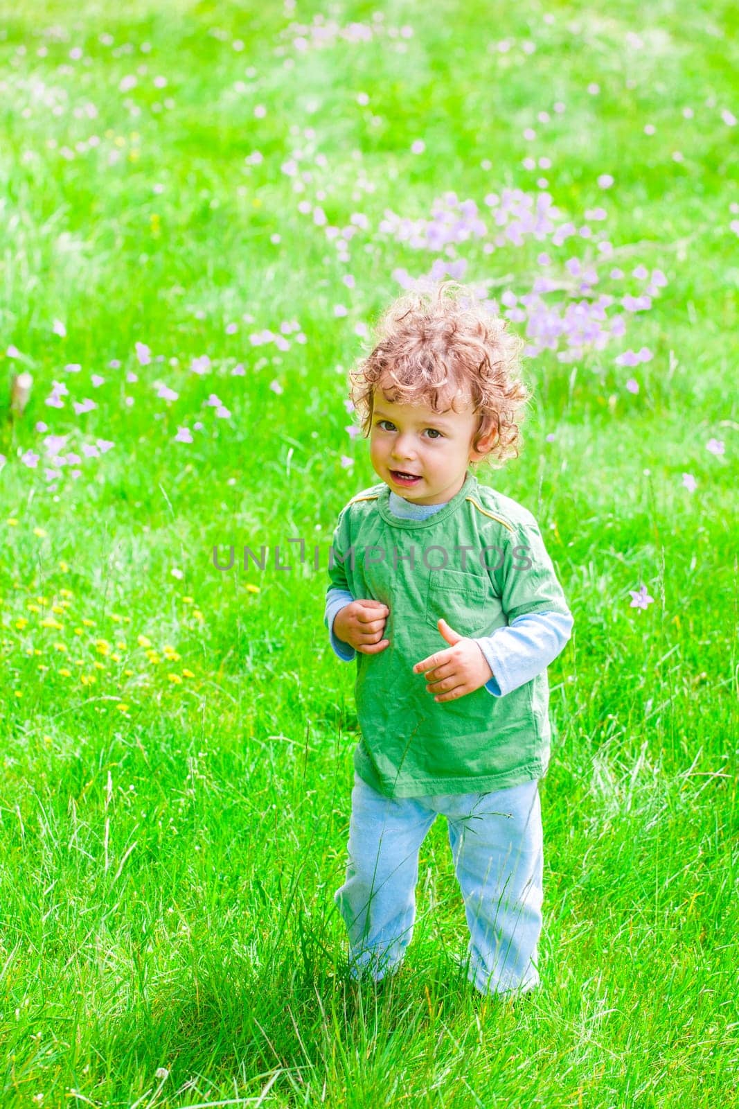 Portrait of 1 year old baby boy having fun on a mountain meadow.