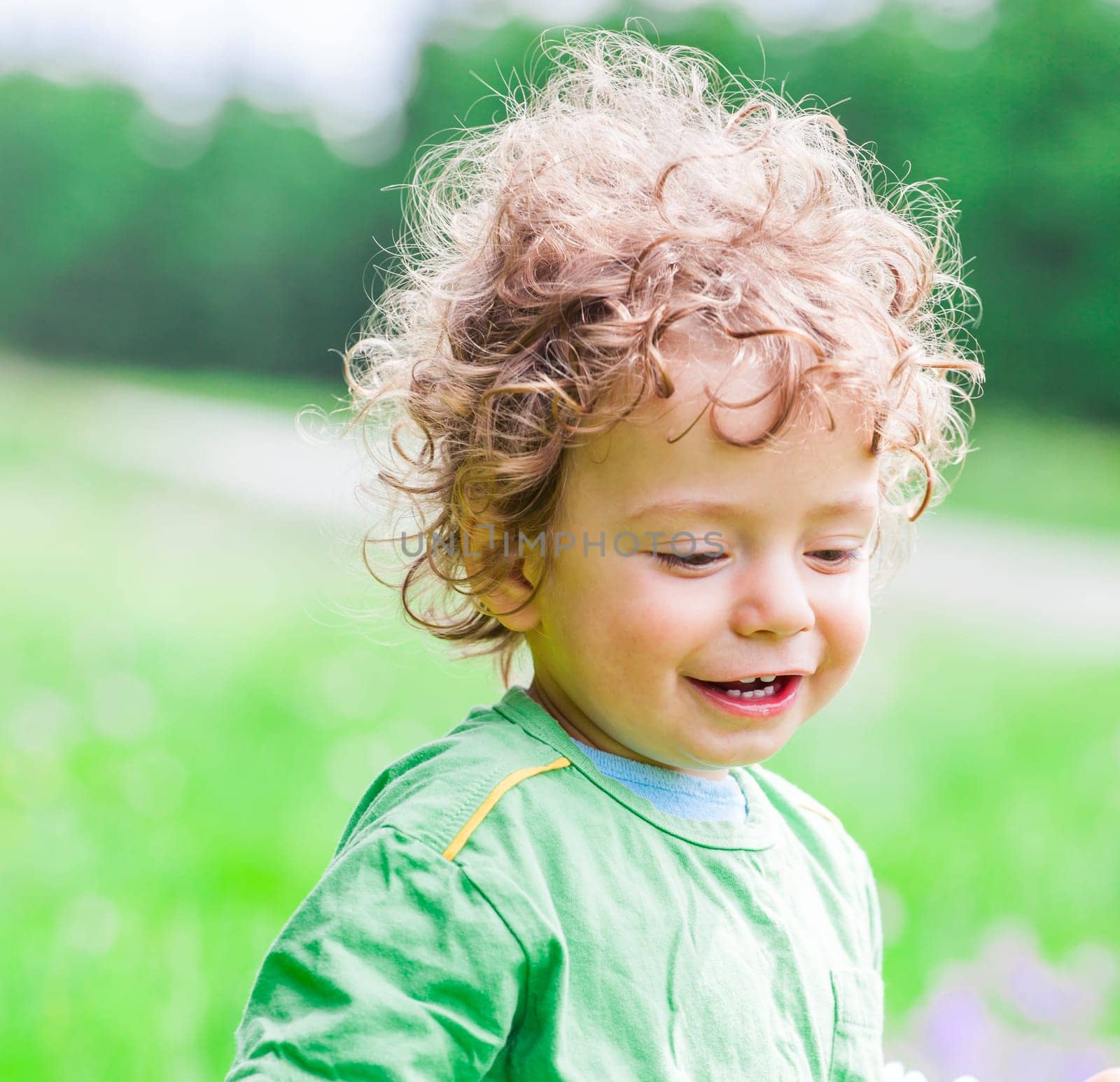 Portrait of 1 year old baby boy having fun on a mountain meadow.