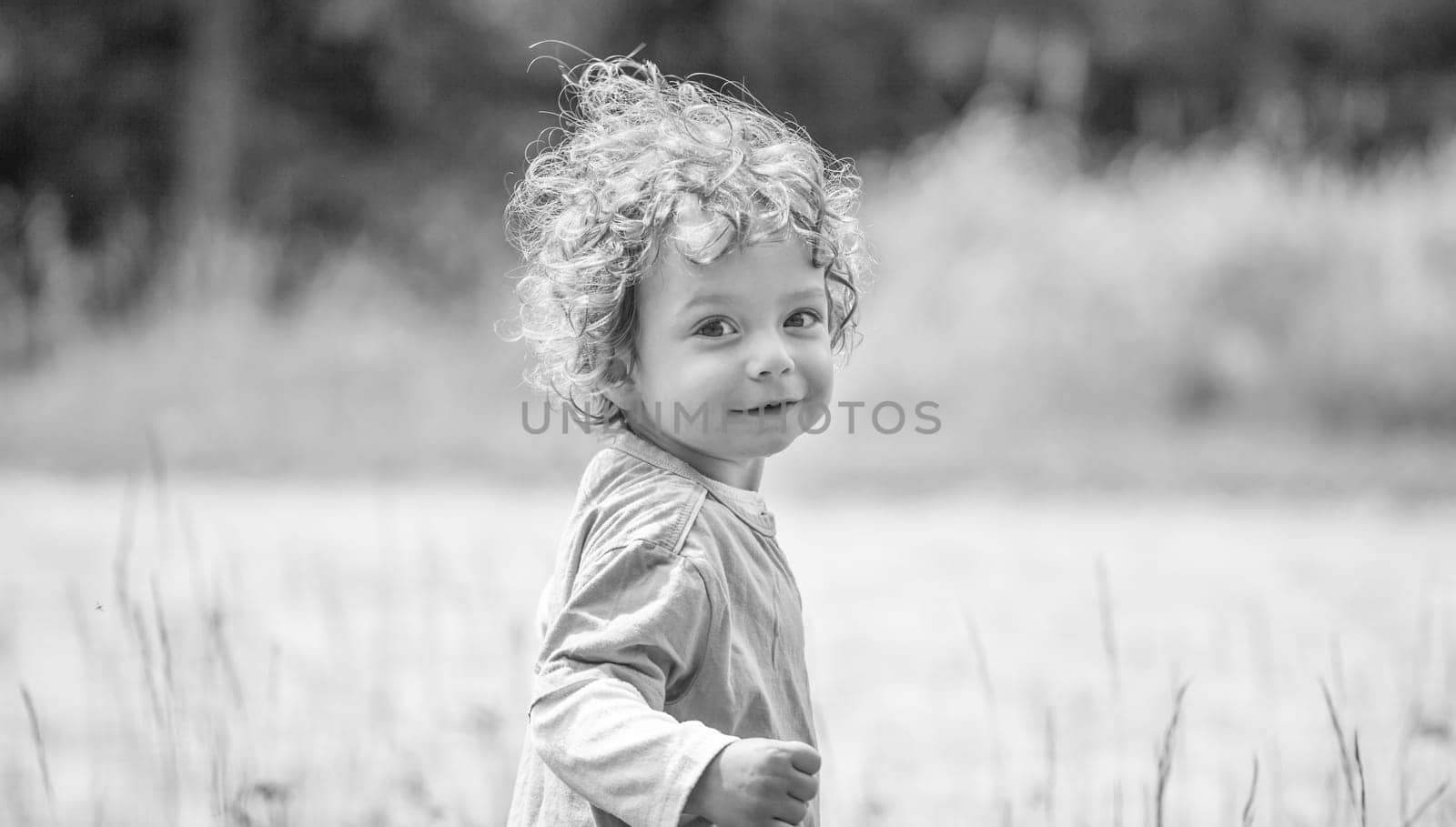 Portrait of 1 year old baby boy having fun on a mountain meadow.