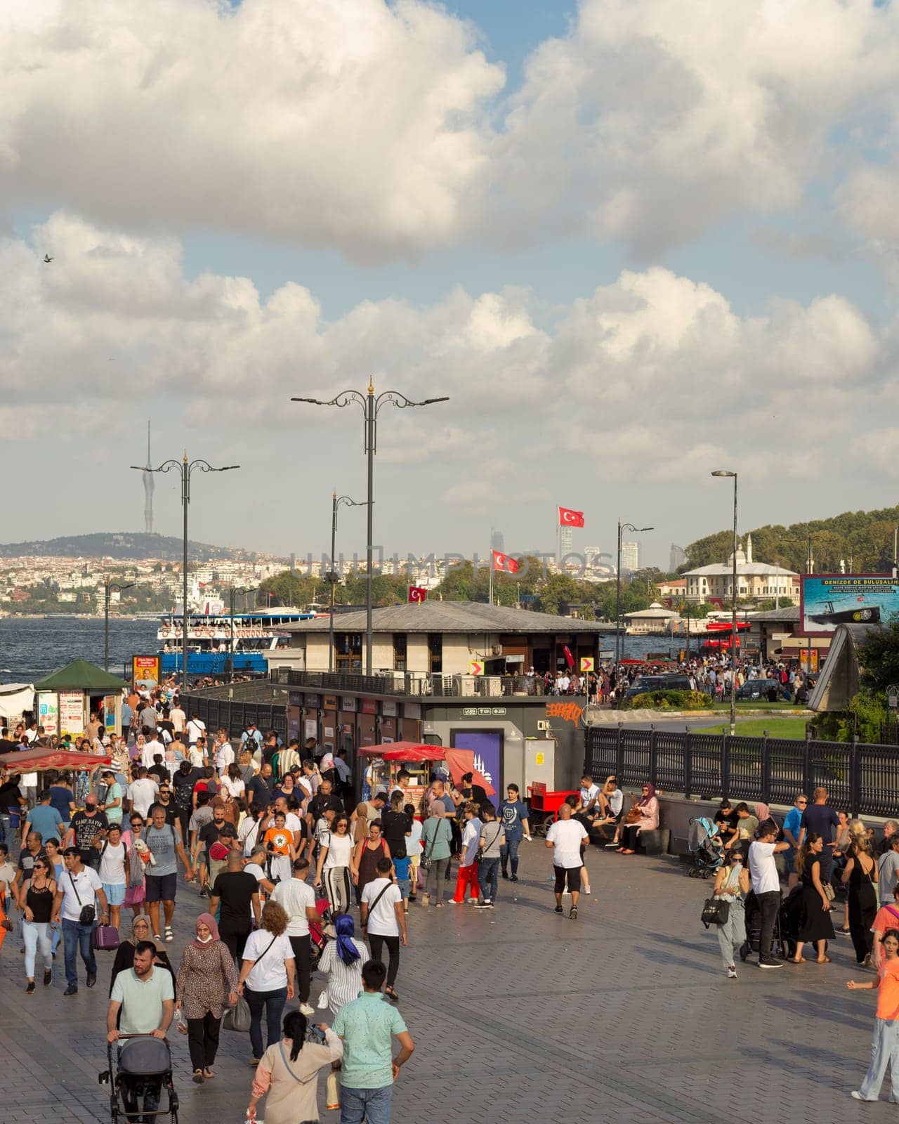 Istanbul, Turkey - August 30, 2022: Crowds of local citizens and tourists at Eminonu Piazza during the Victory Day holiday with background of Istanbul city view