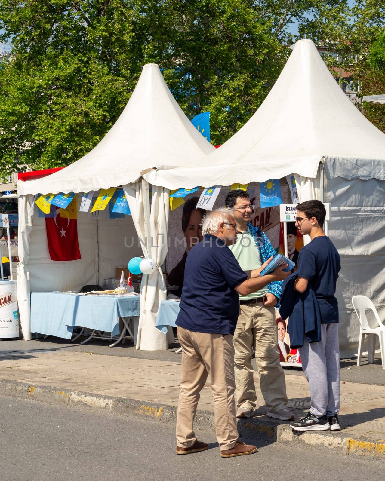 Istanbul, Turkey - May 7 2023: Volunteer hand out flyers in front of an election kiosk of Iyi Party in the neighbourhood of Besiktas during the 2023 elections