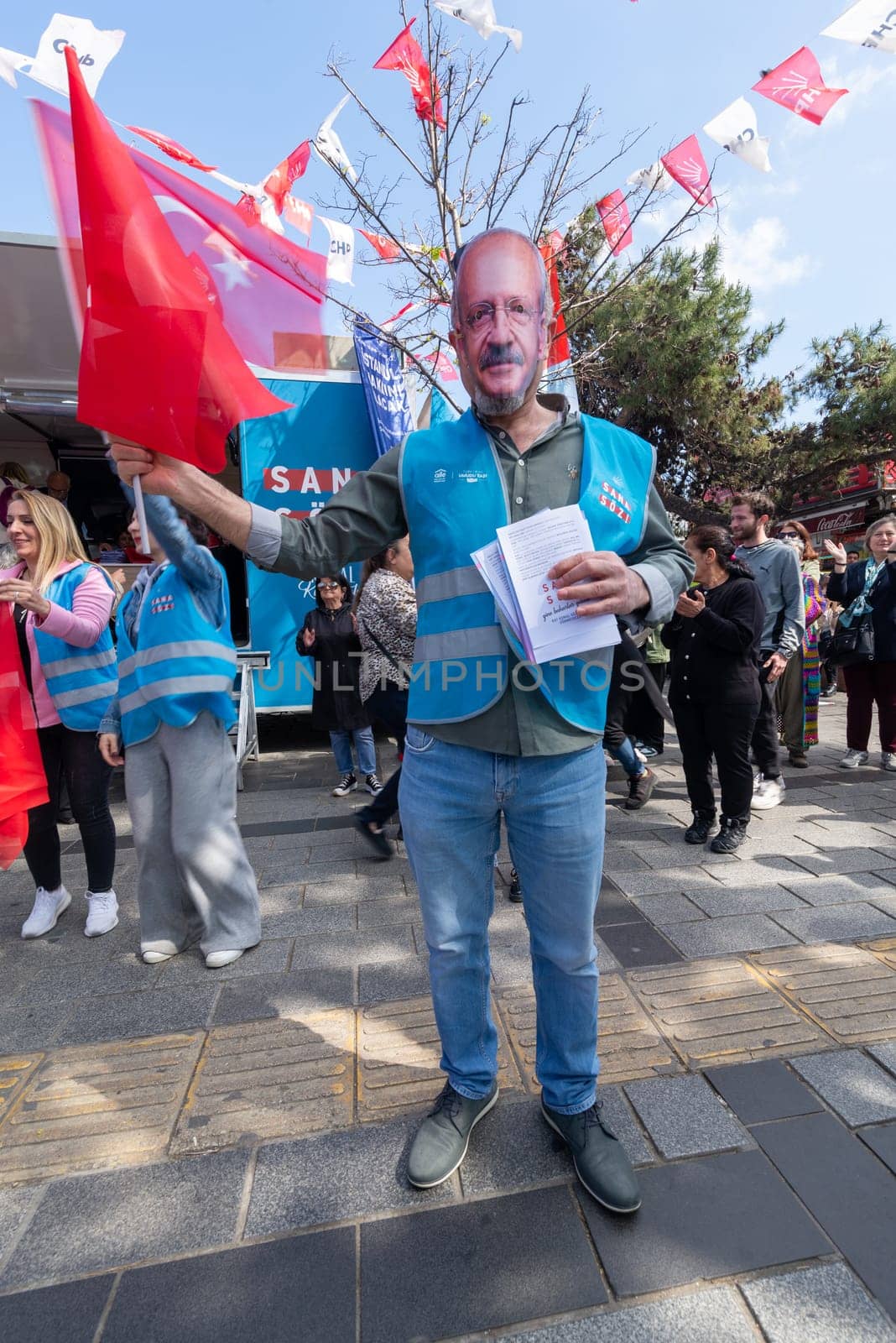 Istanbul, Turkey - May 13 2023: Man wearing a mask of Kemal Kilicdaroglu in front of Republican Peoples Party kiosk in the neighbourhood of Uskudar during the 2023 elections