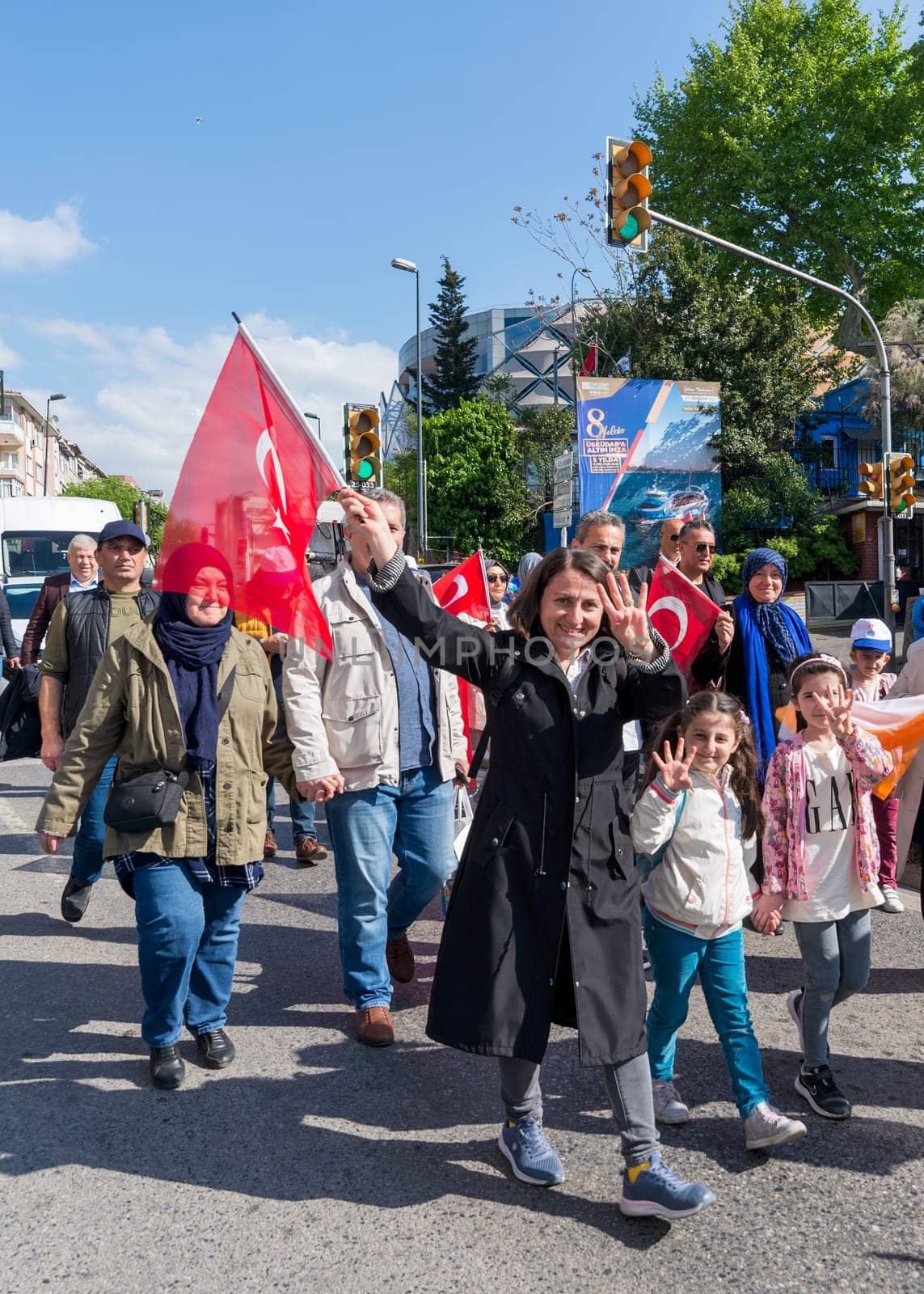 Istanbul, Turkey - May 13 2023: Woman and her children making four fingered sign during march of AK Party in Cumhuriyet street, Uskudar neighbourhood during 2023 elections