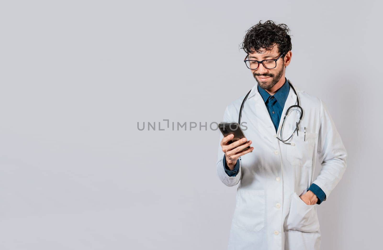 Smiling doctor using cellphone isolated. Young doctor with phone isolated, Doctor with phone on isolated background