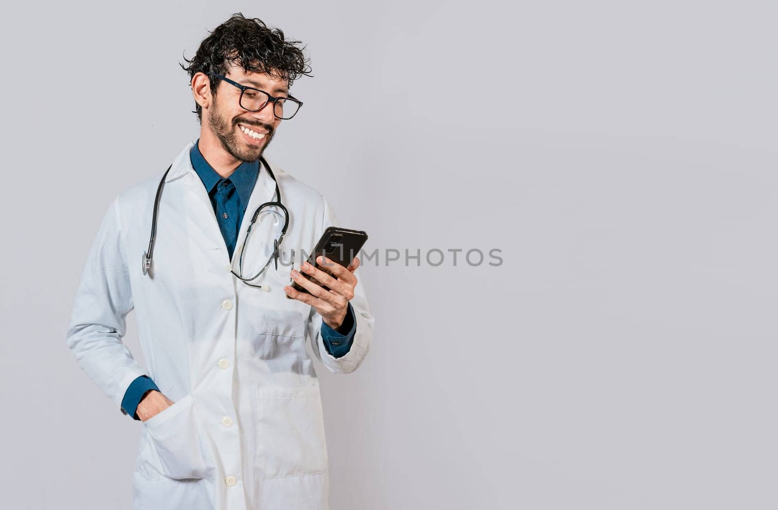 Young doctor with phone isolated, Happy doctor with phone on isolated background. Smiling doctor using cellphone isolated