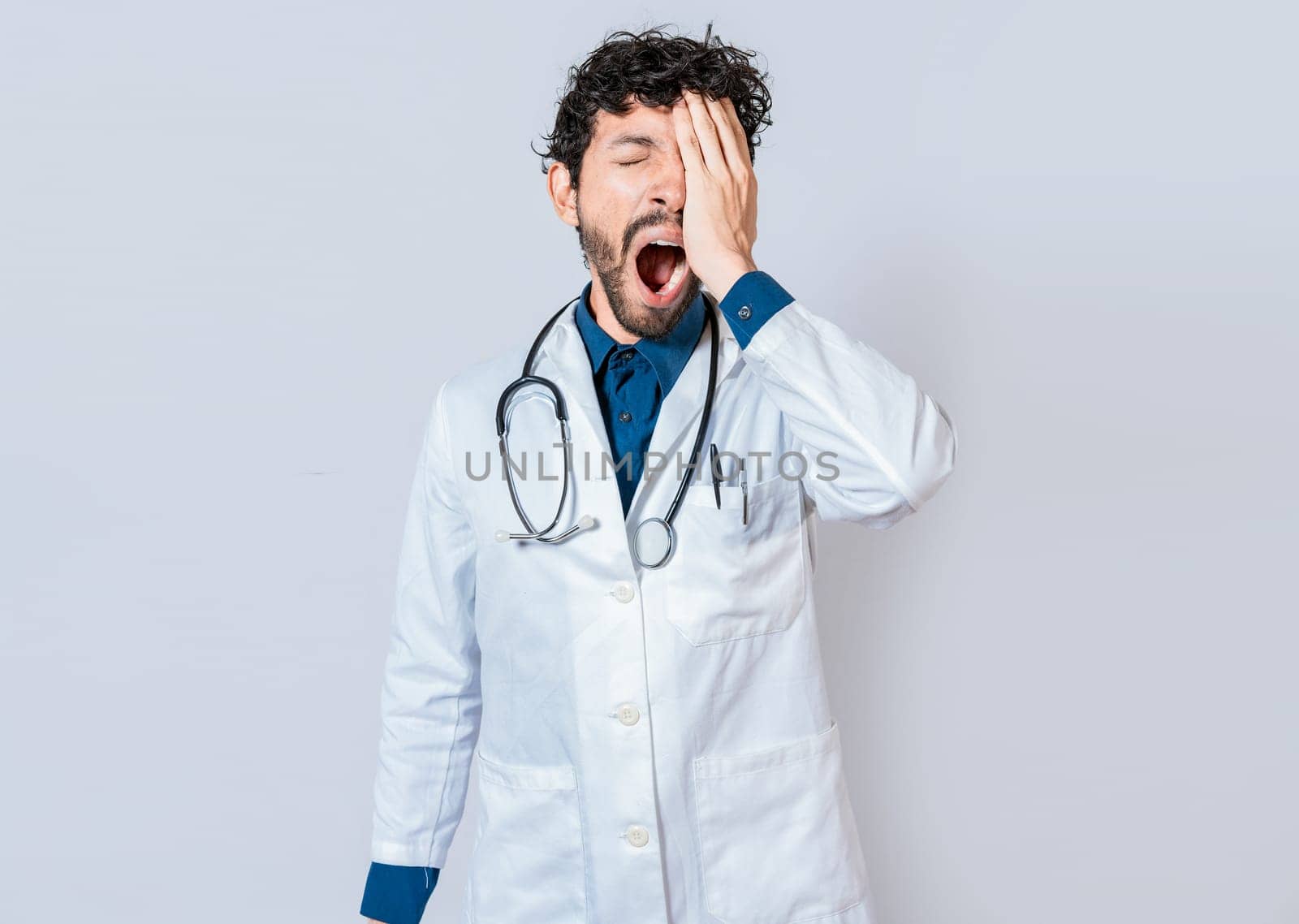 Tired and sleepy doctor isolated. Young sleepy doctor yawning on isolated background. Tired of working doctor concept