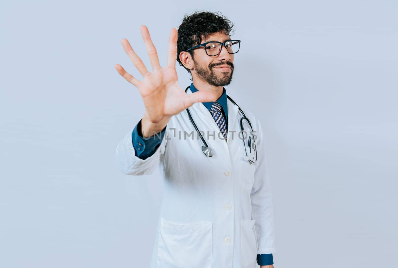 Doctor counting number five isolated. Young doctor counting number 5 on isolated background.