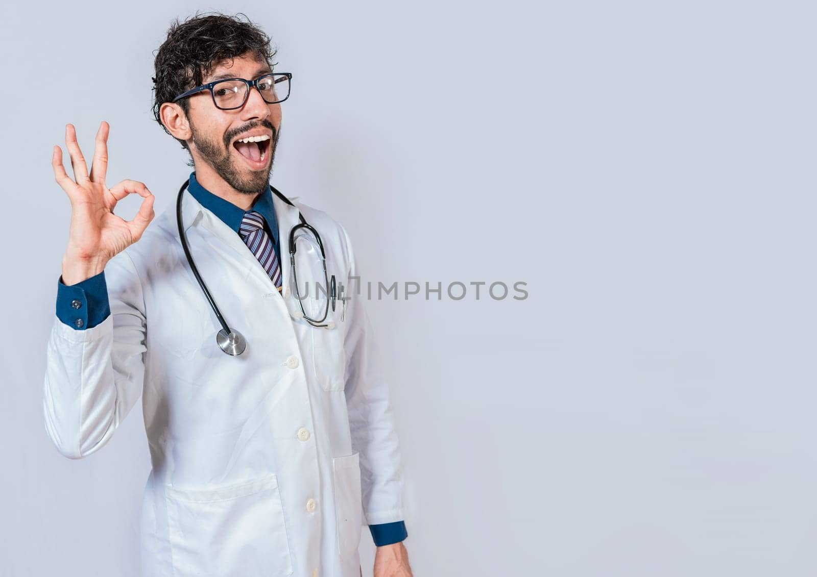 Latin doctor gesturing approval isolated. Handsome doctor approving and recommending isolated