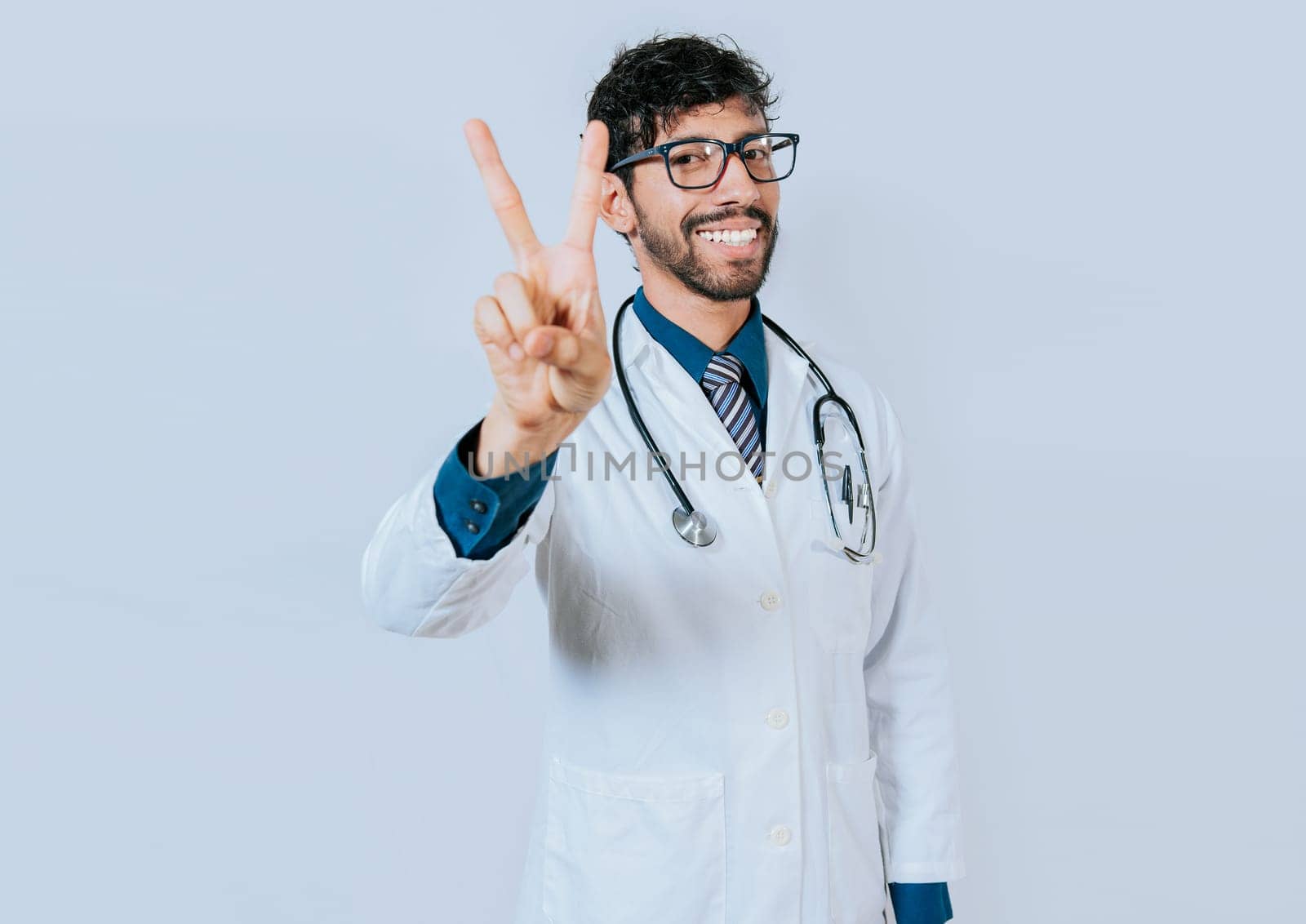 Doctor counting number two isolated. Smiling young doctor counting number 2 on isolated background.