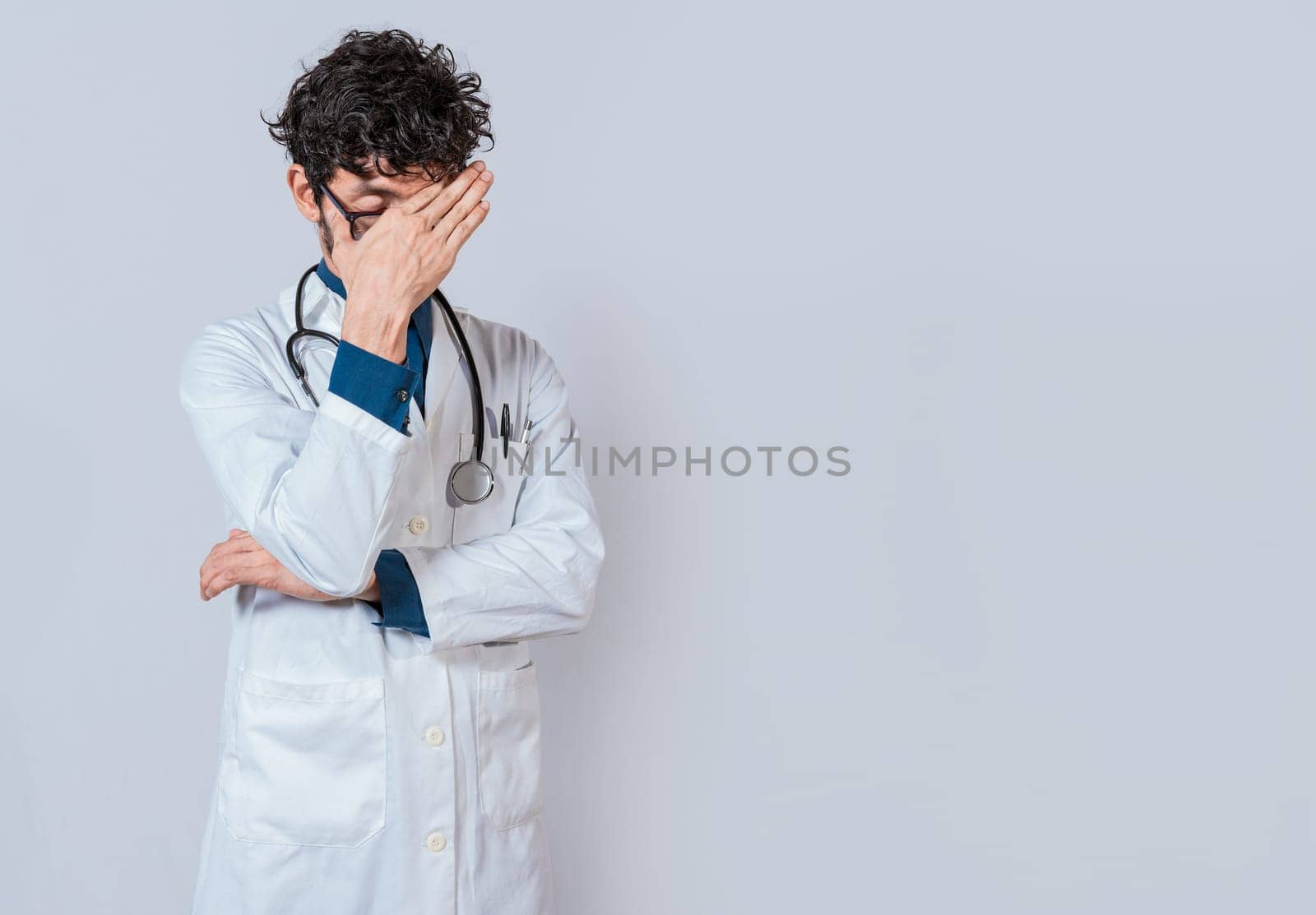 Exhausted doctor with hand on forehead isolated. Tired doctor with hand on forehead