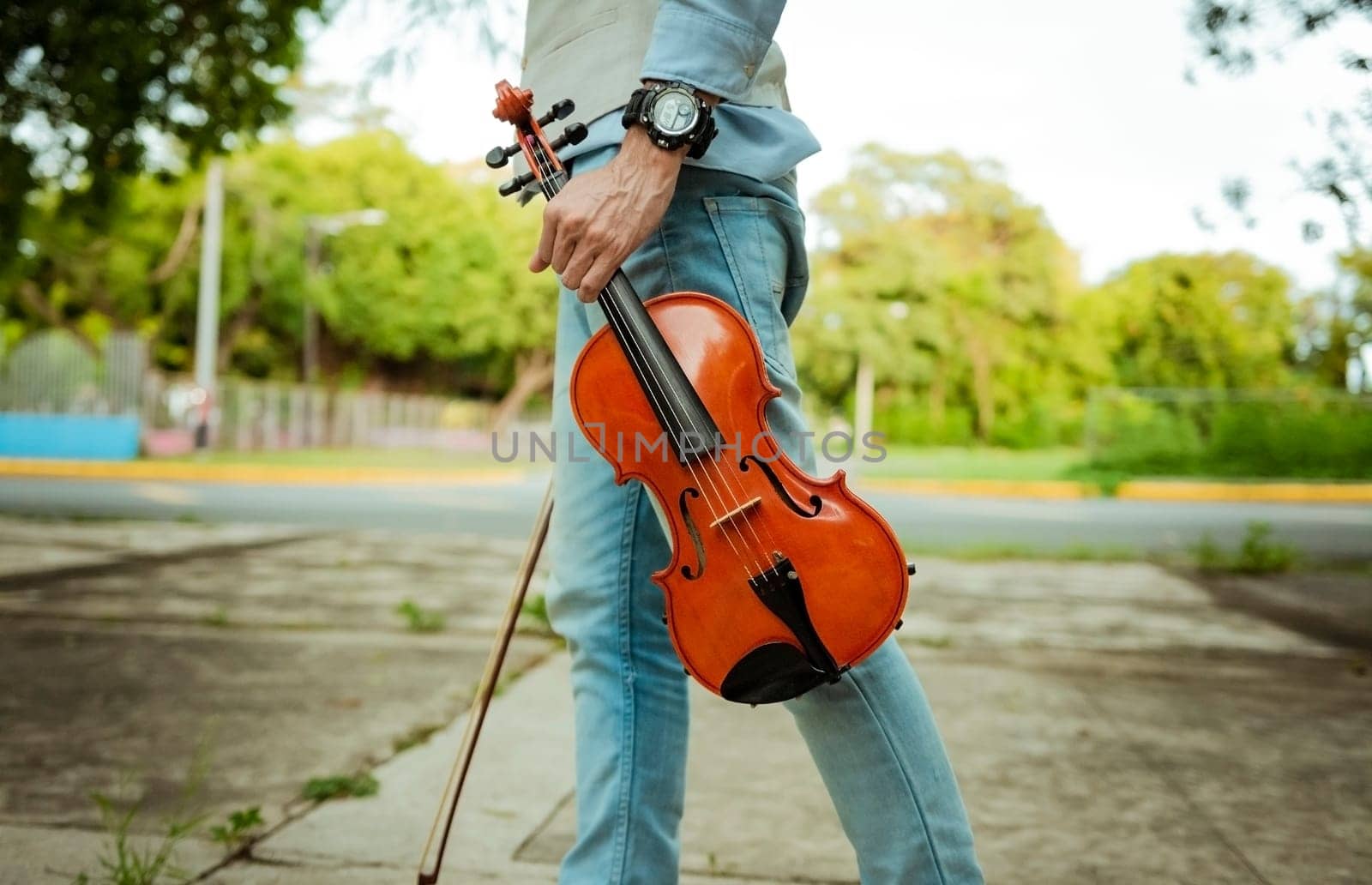 Close up of hands holding violin and hoop. Hands holding violin and hoop outdoors, Concept of person holding violin and hoop outdoors