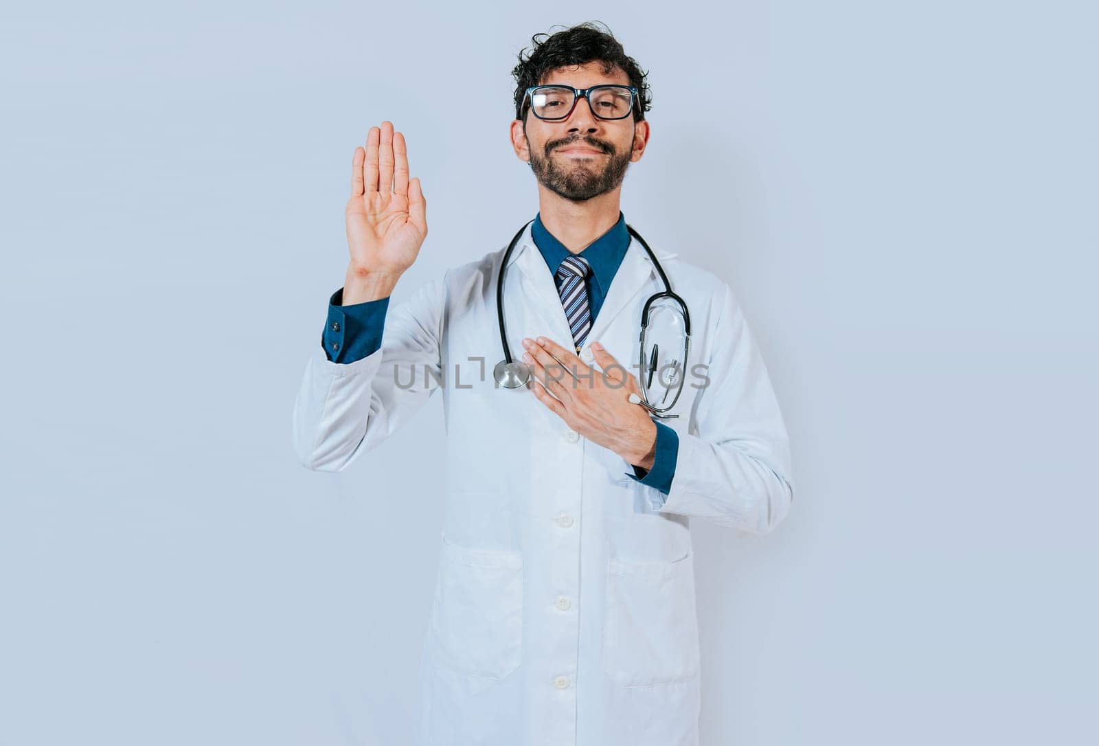 Handsome doctor making oath and promise isolated. Doctor raising hand and swearing