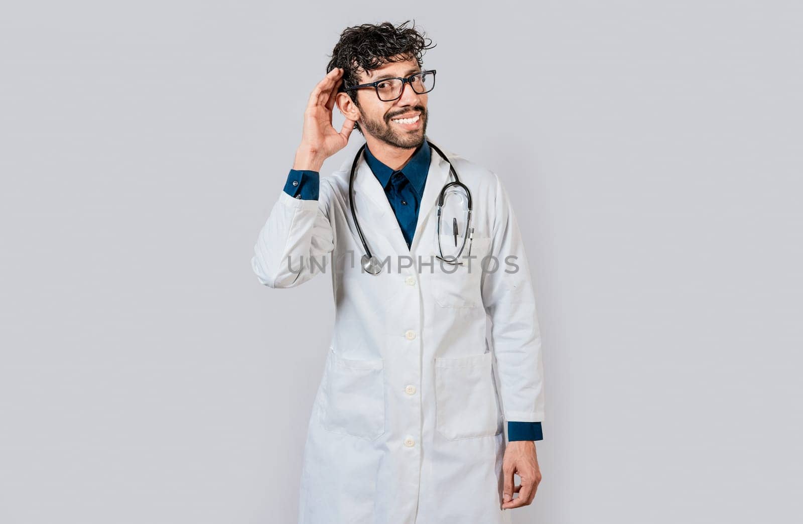 Smiling doctor listening to a rumor. Young doctor smiling with hand over ear isolated, Smiling doctor extending hand isolated