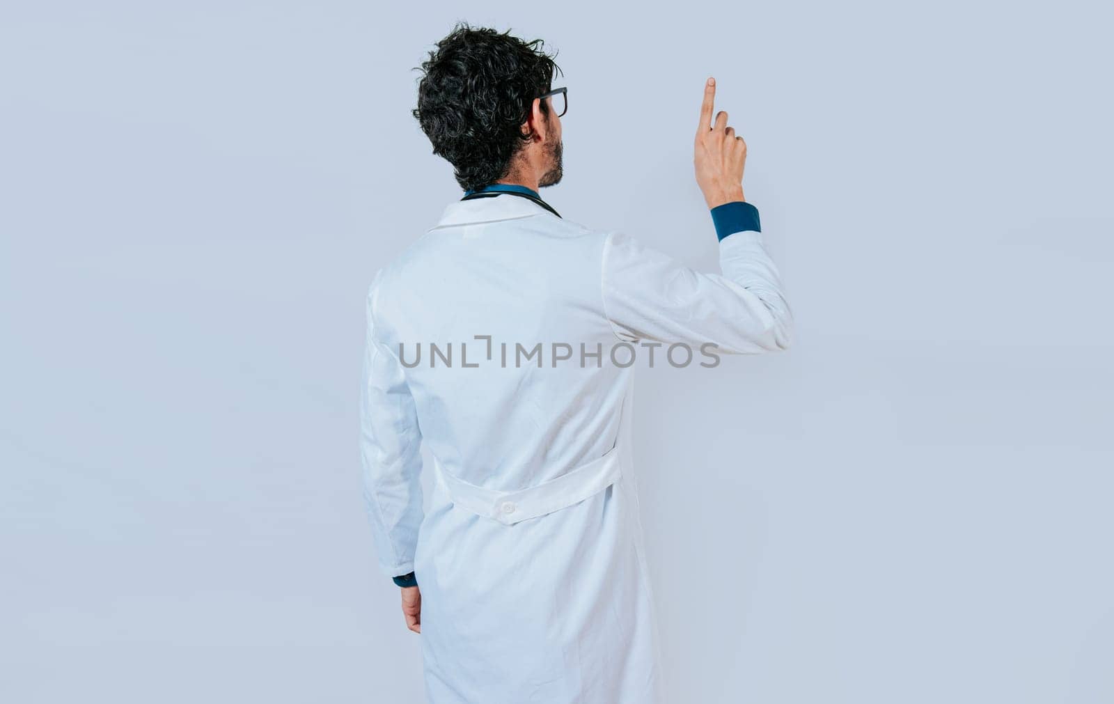 Doctor posing from back pointing finger. Young doctor from back pointing finger isolated.